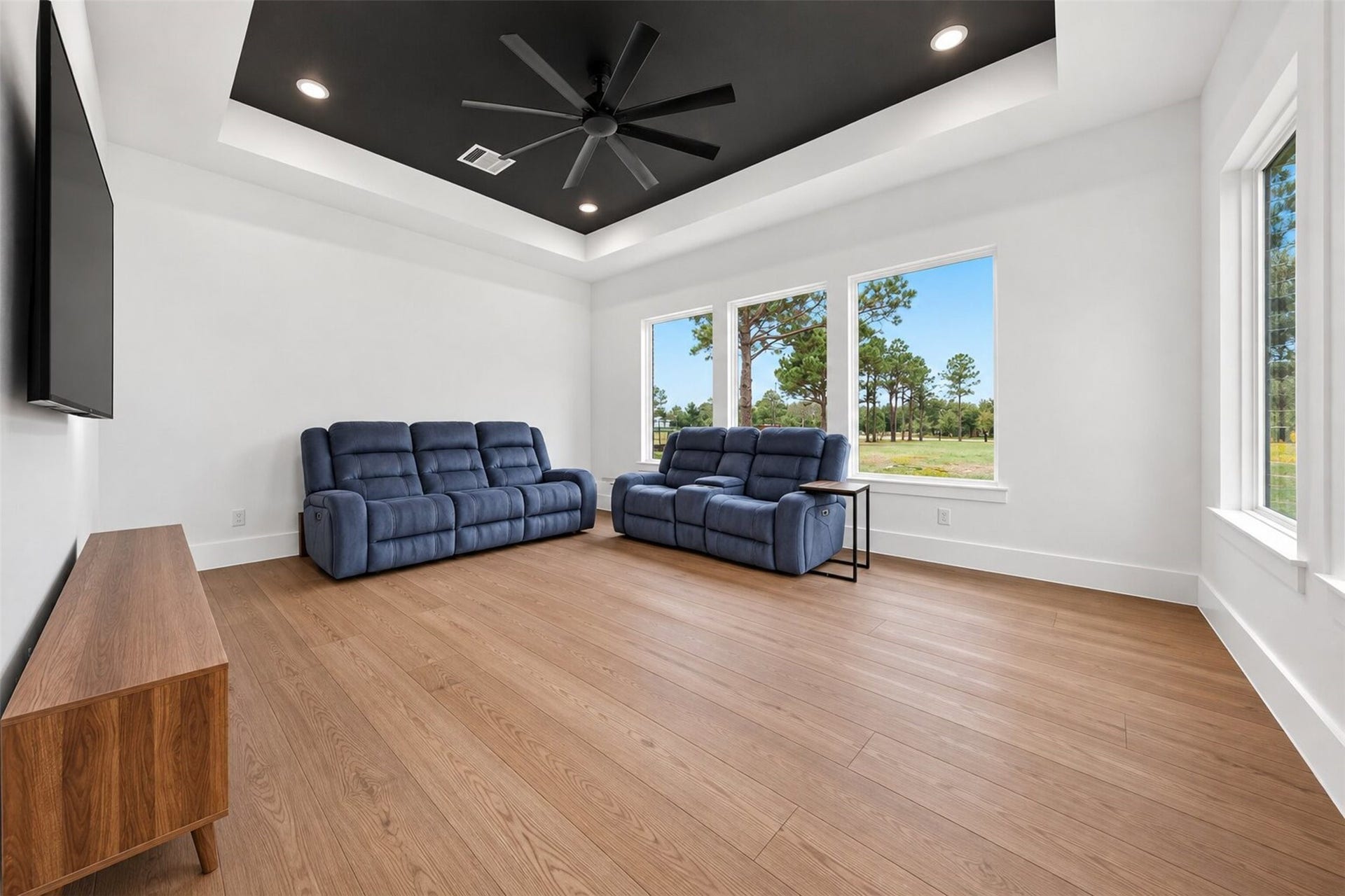 35851 Pineridge Road, Waller, TX 77484 A dark tray ceiling defines the game room, while broad windows bring in natural light and views of the surrounding property.
