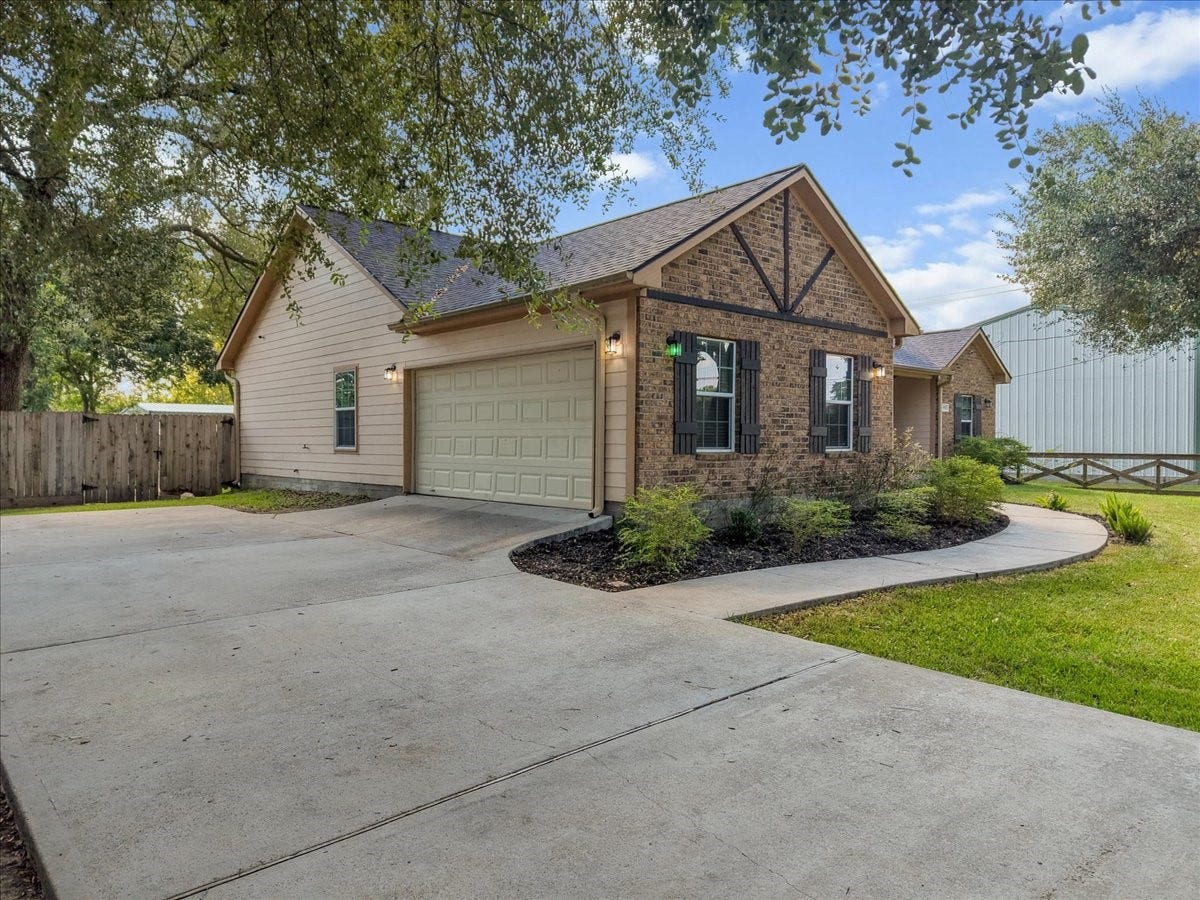 15531 Maple Street, Santa Fe, TX 77517 Tucked beneath a canopy of mature oaks, this brick ranch charms from the curb with dormer accents, a deep covered porch, and a rich wood front door that sets a warm, welcoming tone.