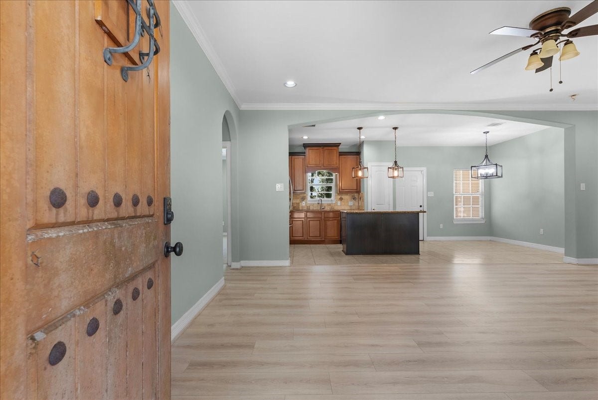 15531 Maple Street, Santa Fe, TX 77517 Step through the front door into a bright, open floor plan where wide-plank flooring and soft sage tones carry through the living space into the kitchen.