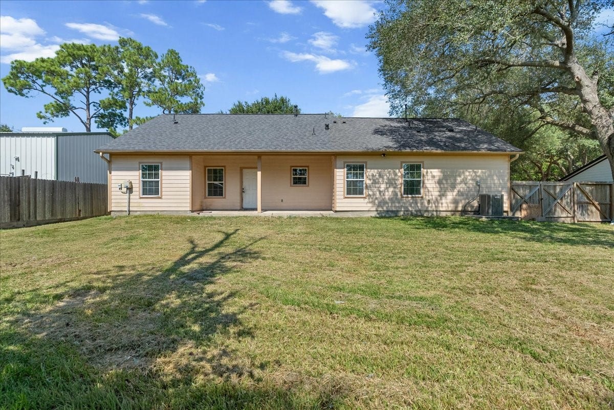 15531 Maple Street, Santa Fe, TX 77517 A covered back porch spans a good portion of the rear elevation, complete with an exterior door leading in from the yard. A double-gate side entry and privacy fence enclose the full width of the property, keeping the backyard secure.