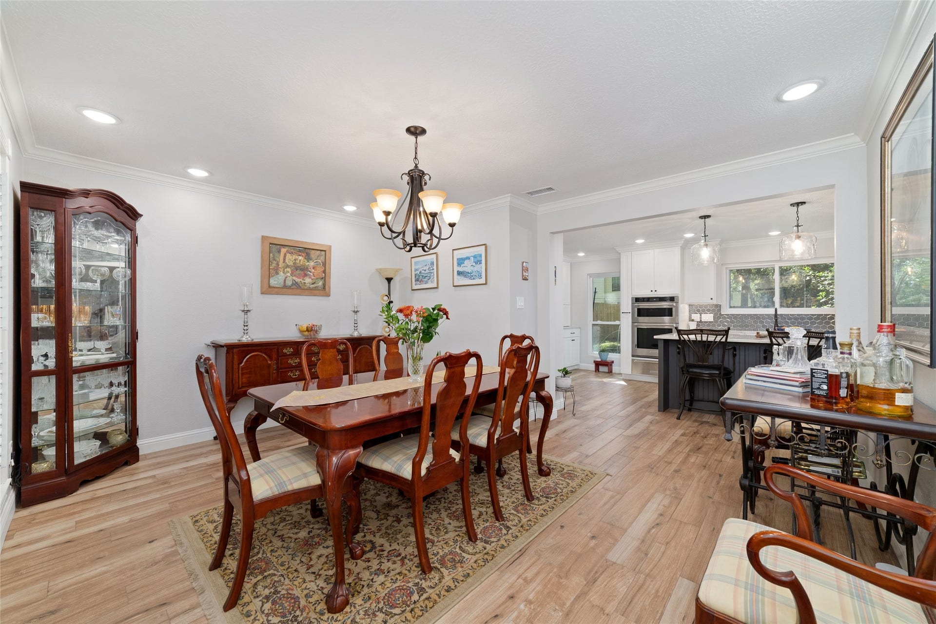 218 E Rainbow Ridge Circle, The Woodlands, TX 77381 Elegant dining area seamlessly connects to a modern, open kitchen with ample natural light and sleek appliances.