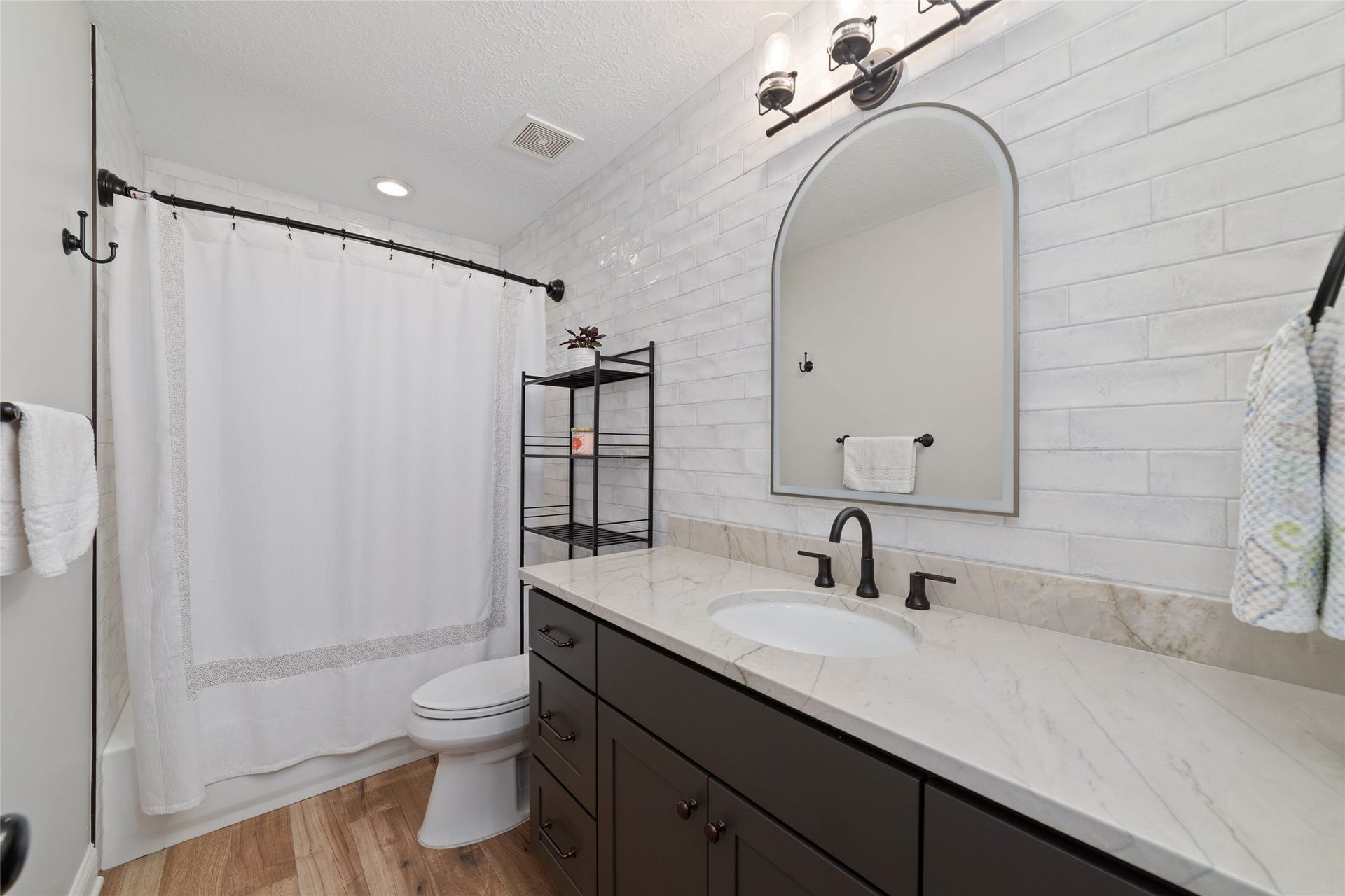 218 E Rainbow Ridge Circle, The Woodlands, TX 77381 Elegant secondary bathroom featuring a sleek vanity with gorgeous countertop, modern fixtures, and a spacious custom tile shower.