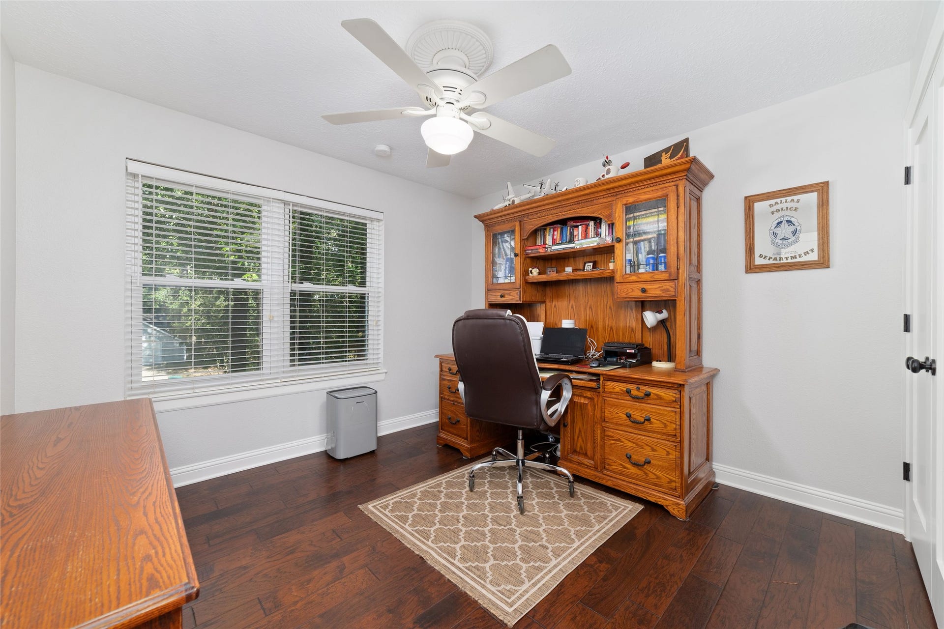 218 E Rainbow Ridge Circle, The Woodlands, TX 77381 Secondary bedroom, which the seller is using as a home office, features rich hardwood floors, enhanced by natural light from a double window.