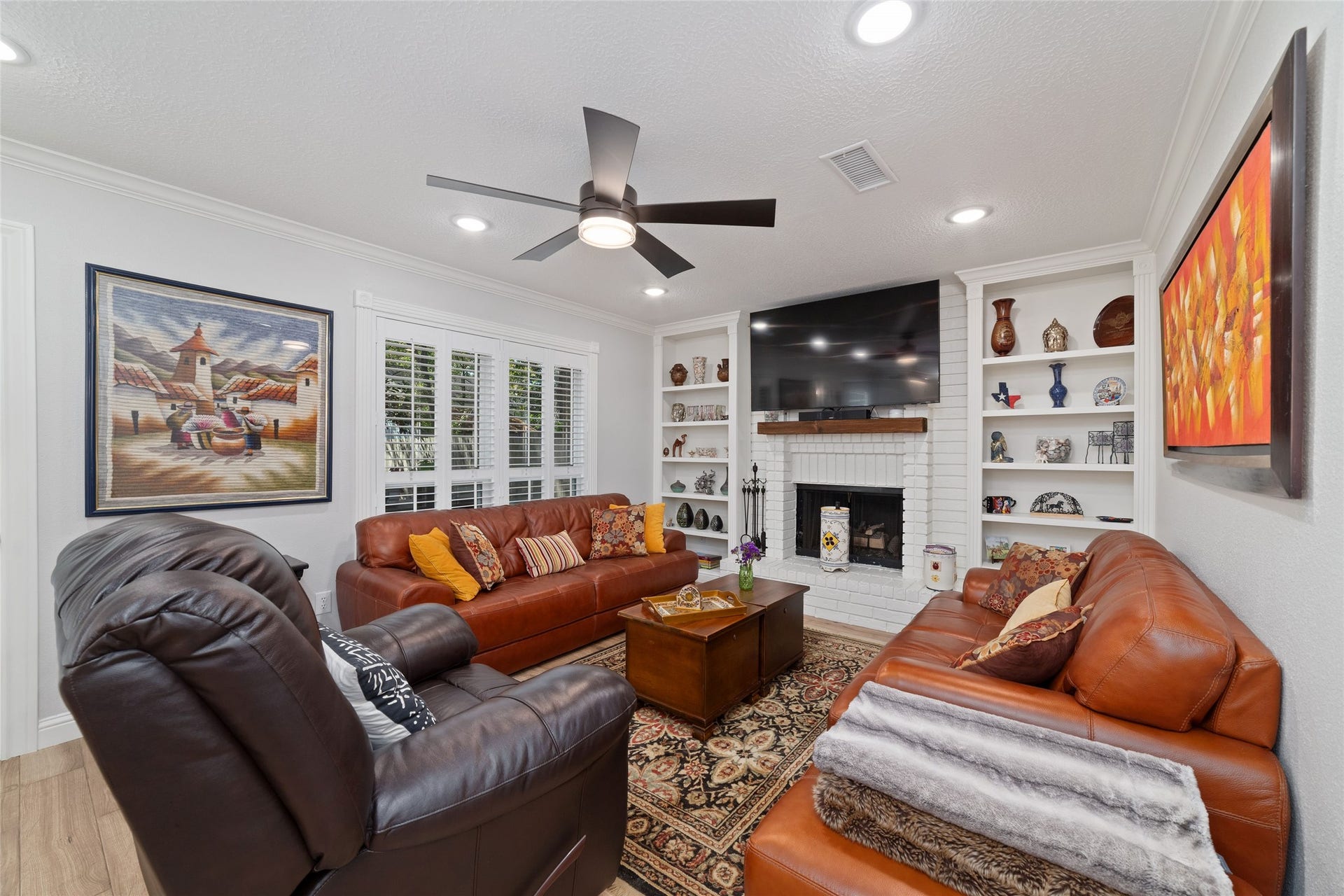 218 E Rainbow Ridge Circle, The Woodlands, TX 77381 Cozy living room featuring a white brick fireplace surrounded by built-in shelves for a warm, inviting atmosphere.