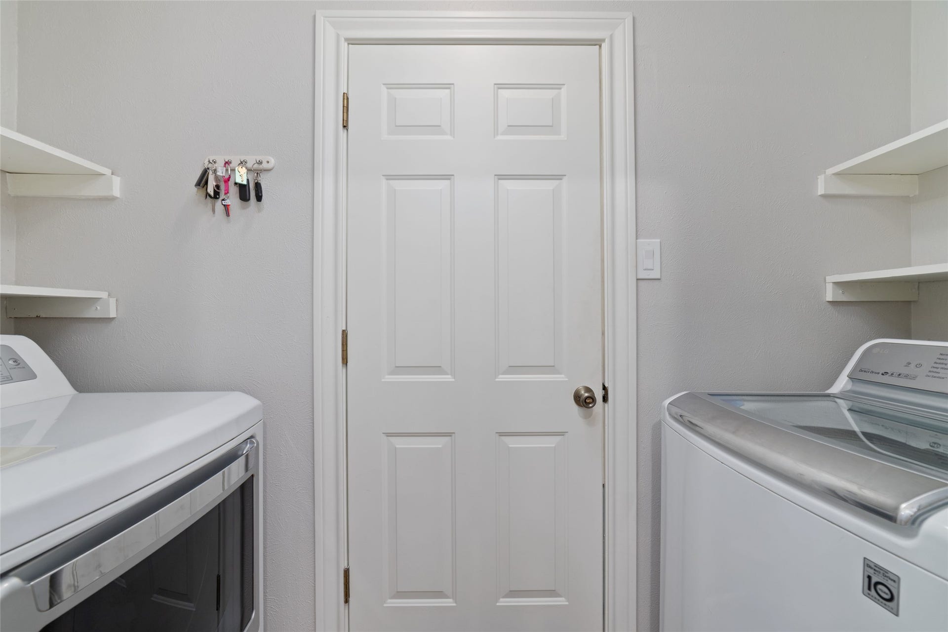218 E Rainbow Ridge Circle, The Woodlands, TX 77381 Laundry room features ample shelving for storage, and convenient access to the garage.