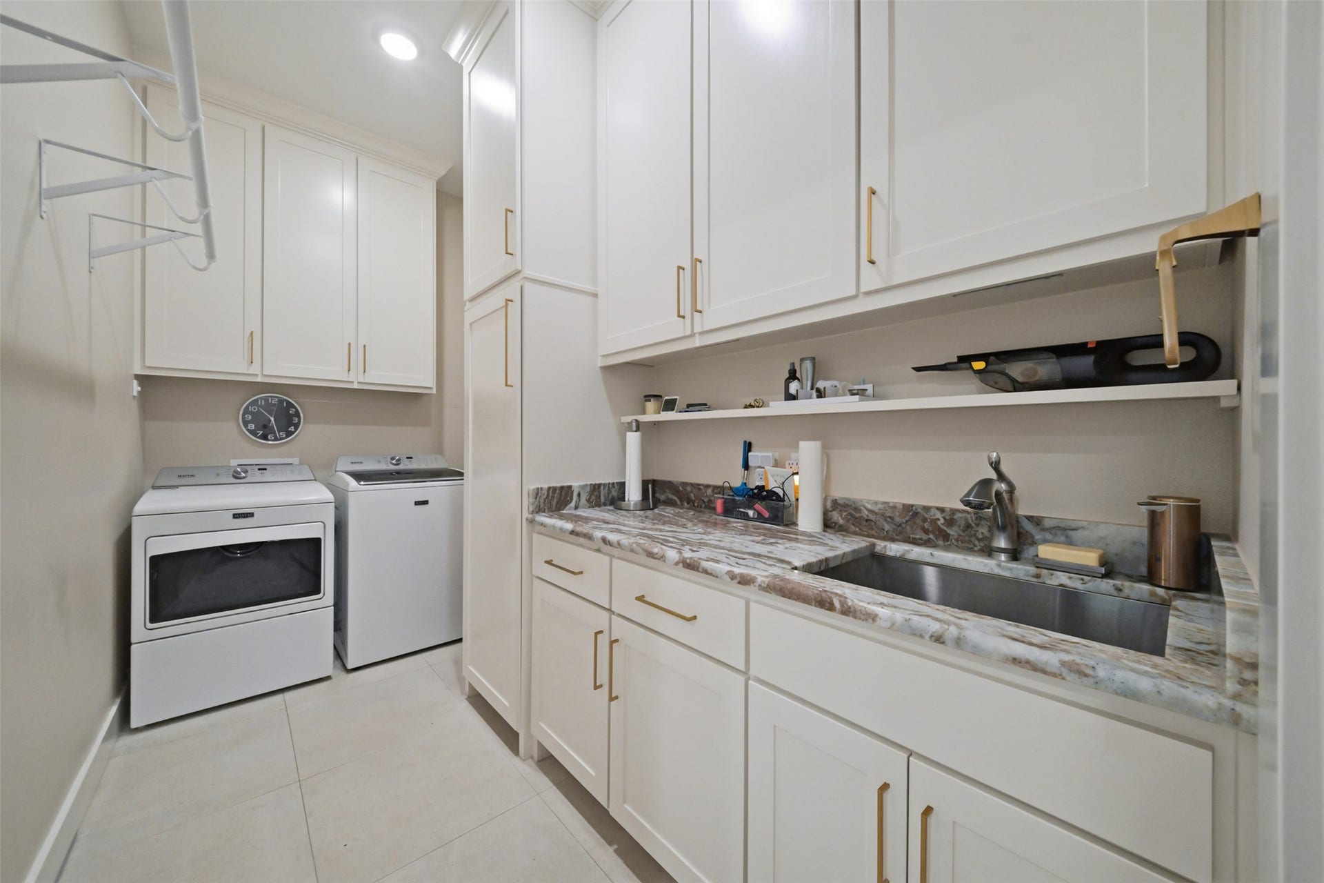 5117 Inverness Drive, Bryan, TX 77802 Spacious laundry room with an oversized single-basin sink, abundant cabinetry and hanging space, plus direct access from the primary closet for added convenience.