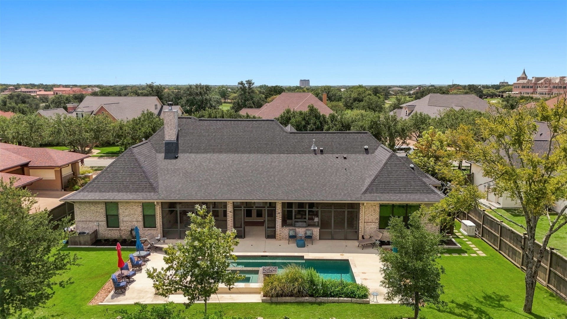 5117 Inverness Drive, Bryan, TX 77802 Aerial view showcasing the homes expansive backyard, pool, screened porch and surrounding green space.