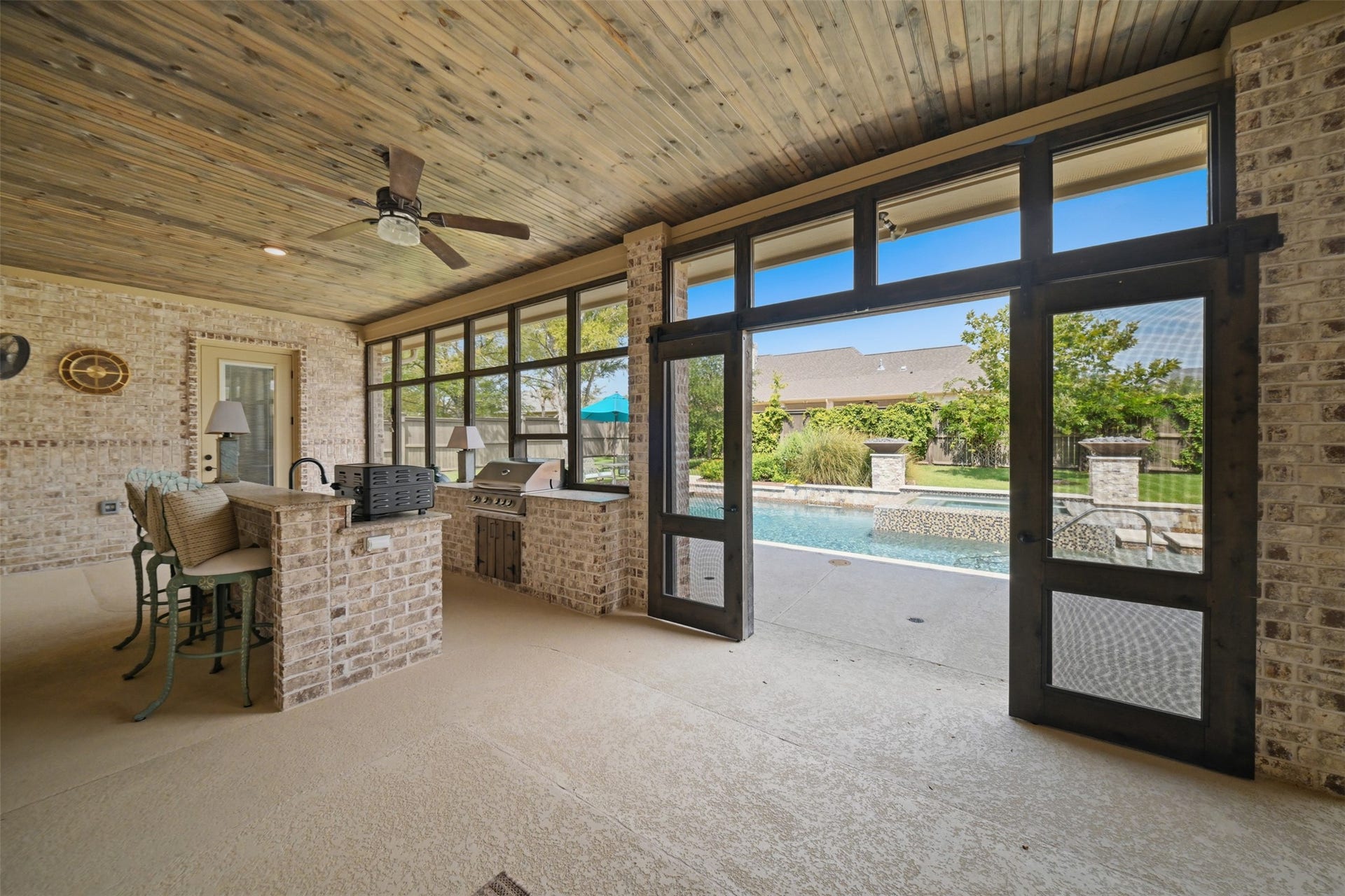 5117 Inverness Drive, Bryan, TX 77802 Another view of the expansive screened-in porch, highlighting the outdoor kitchen, stained wood ceiling and direct access to the pool.
