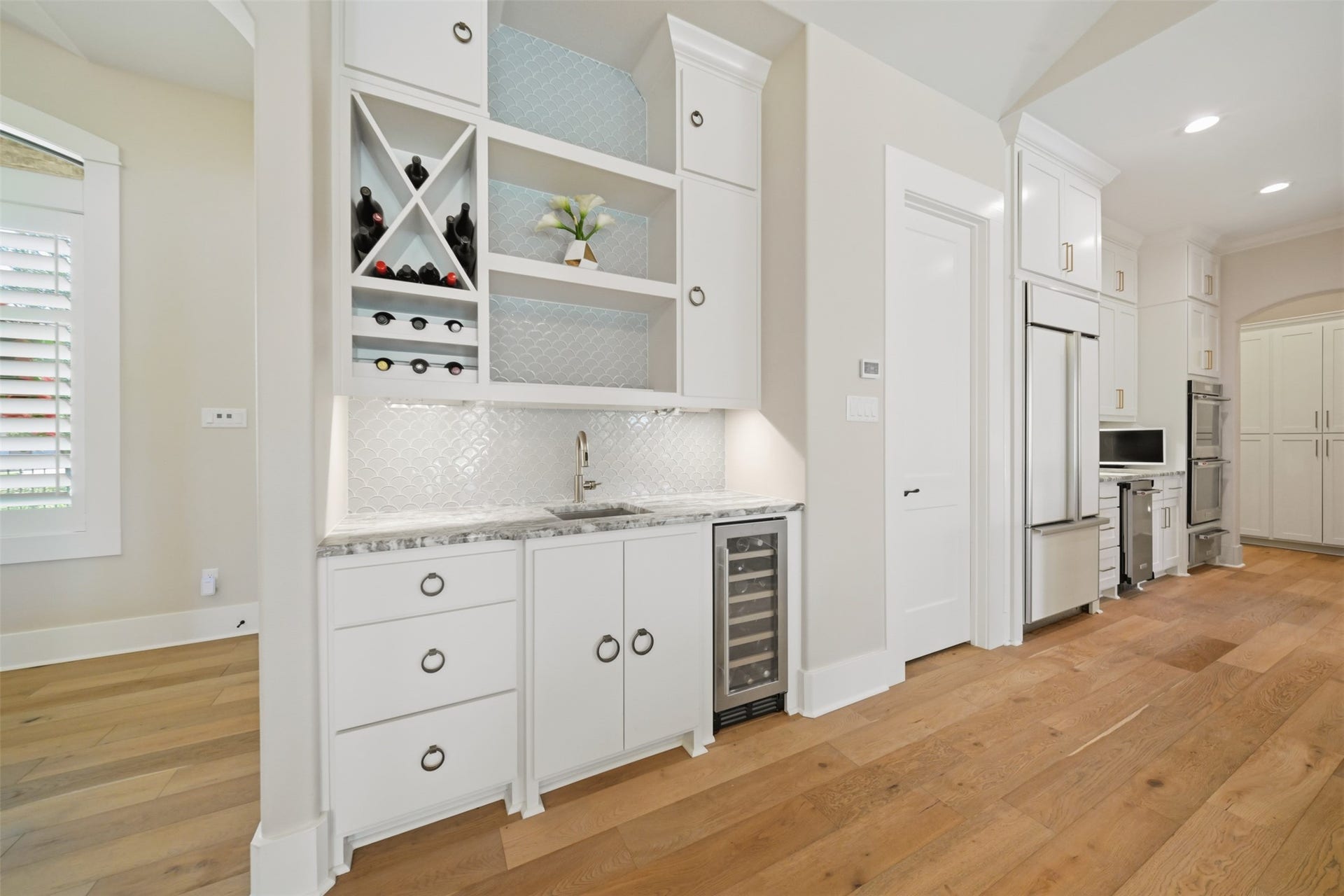 5117 Inverness Drive, Bryan, TX 77802 Wet bar featuring a sink, custom cabinetry, built-in wine refrigerator, and dedicated wine storage.