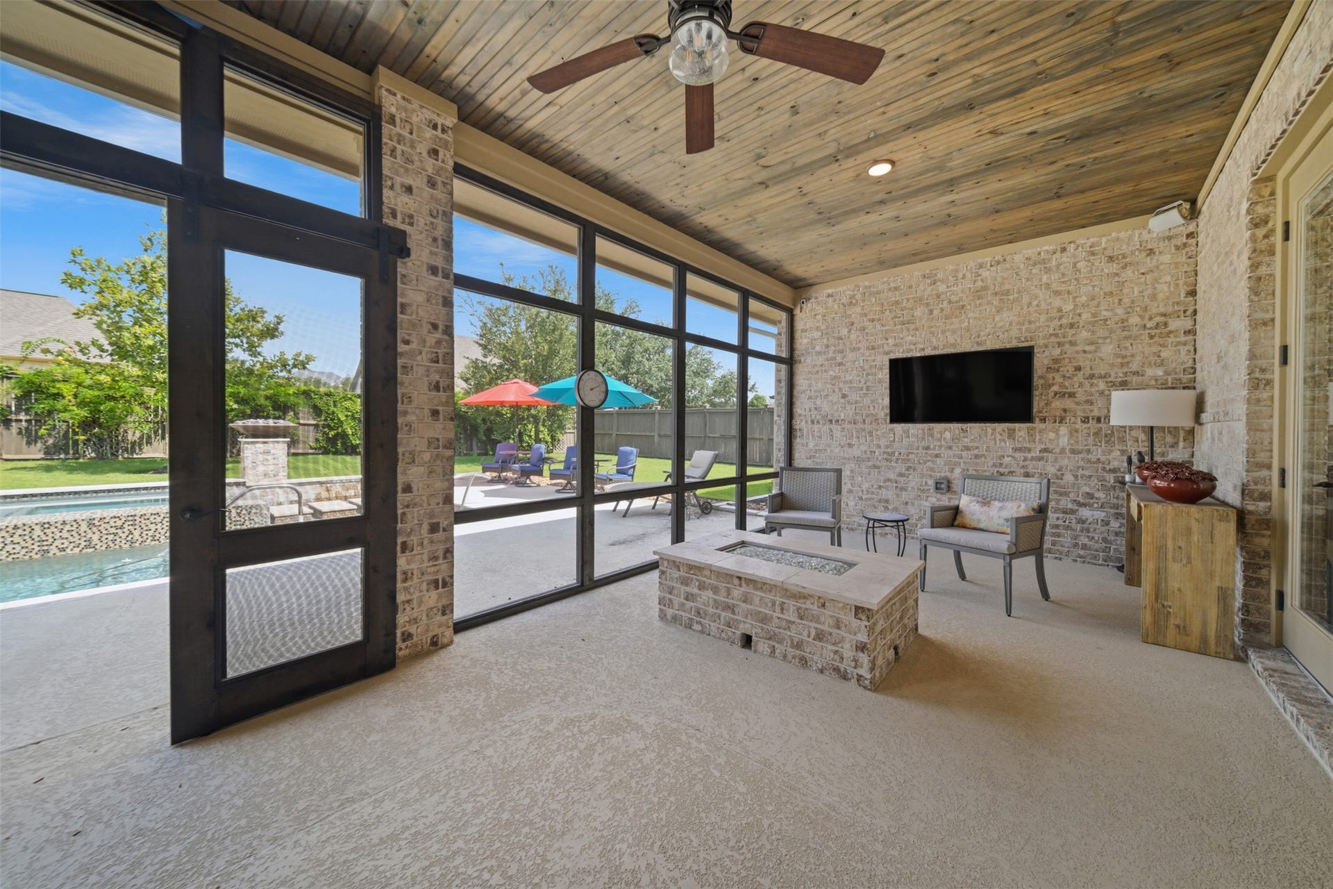5117 Inverness Drive, Bryan, TX 77802 Built-in fire pit creates a cozy gathering space within the expansive screened-in patio, just steps from the pool.