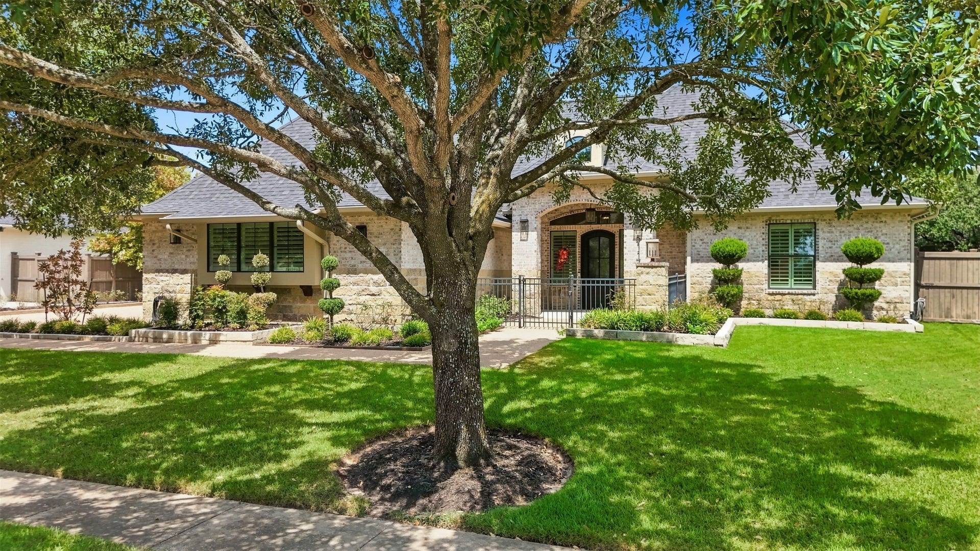 5117 Inverness Drive, Bryan, TX 77802 Beautiful curb appeal with mature shade tree and lush landscaping.