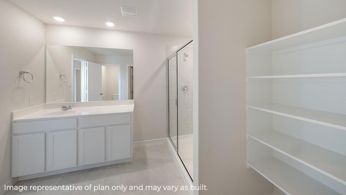 3831 Turnpike Drive, Fulshear, TX 77441 Bright and spacious bathroom featuring a sleek vanity with ample storage, a large mirror, and a modern glass-enclosed shower.