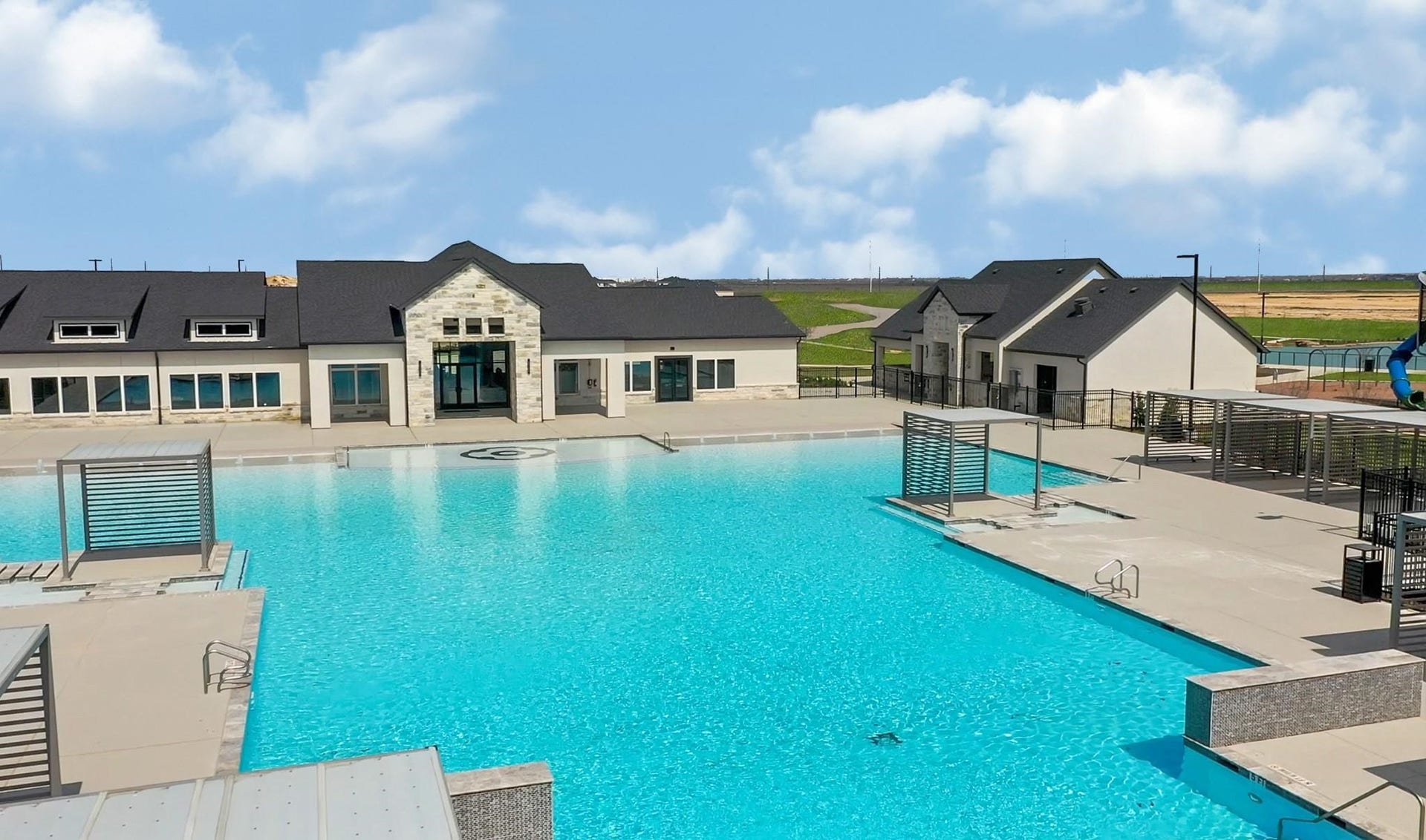 3831 Turnpike Drive, Fulshear, TX 77441 Discover a luxurious community pool with expansive deck space and modern amenities, perfect for relaxation and gatherings.
