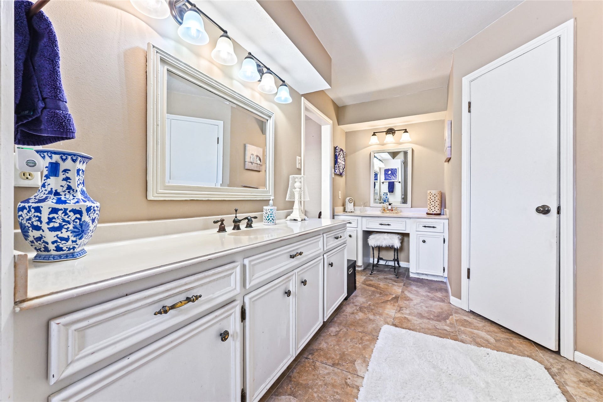 25803 Maplewood Drive, Spring, TX 77386 Spacious bathroom featuring dual vanities with elegant white cabinetry, stylish lighting, and a cozy makeup station for a luxurious touch.