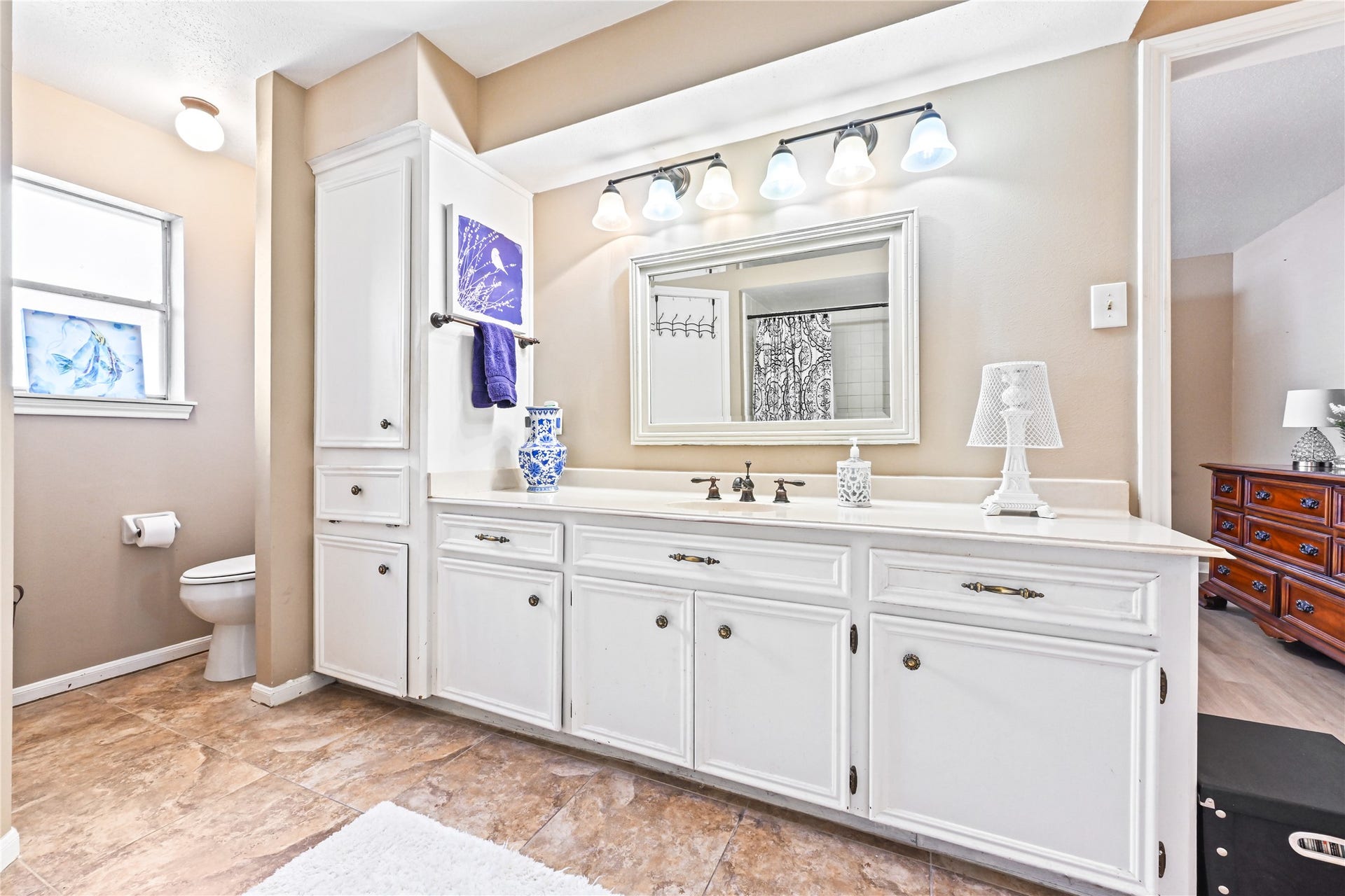 25803 Maplewood Drive, Spring, TX 77386 Spacious bathroom featuring a double vanity with ample storage, elegant lighting, and a large mirror, complemented by a neutral color palette and tasteful decor.
