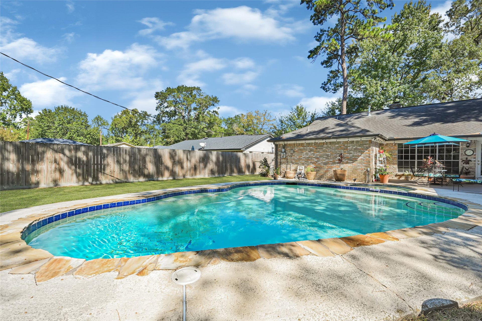 25803 Maplewood Drive, Spring, TX 77386 Charming backyard oasis featuring a sparkling pool surrounded by a spacious patio, perfect for relaxation and entertaining.
