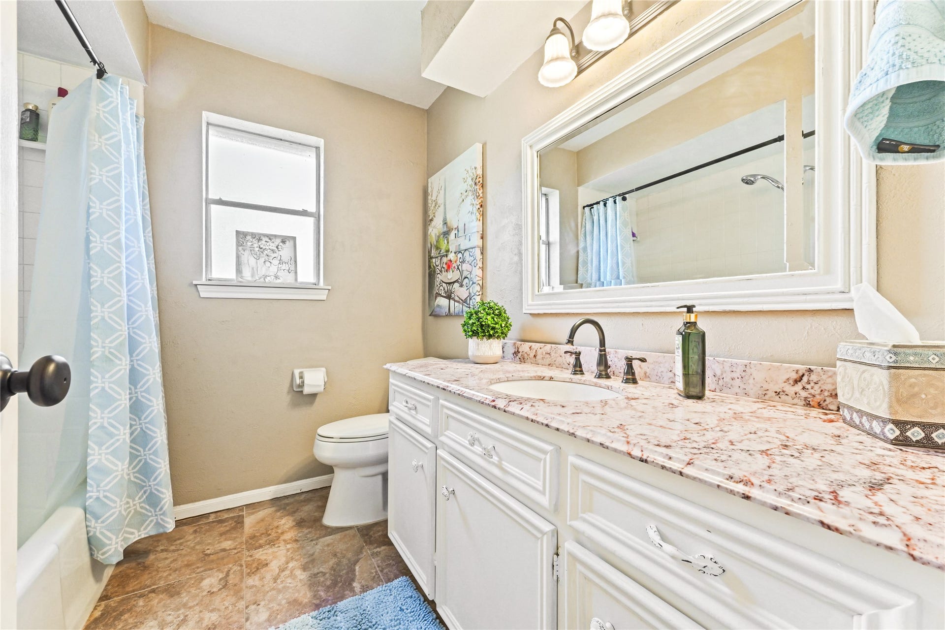 25803 Maplewood Drive, Spring, TX 77386 Bright and inviting bathroom featuring a spacious vanity with dual sinks, elegant granite countertops, and stylish fixtures. Natural light pours in through the window, enhancing the serene atmosphere.
