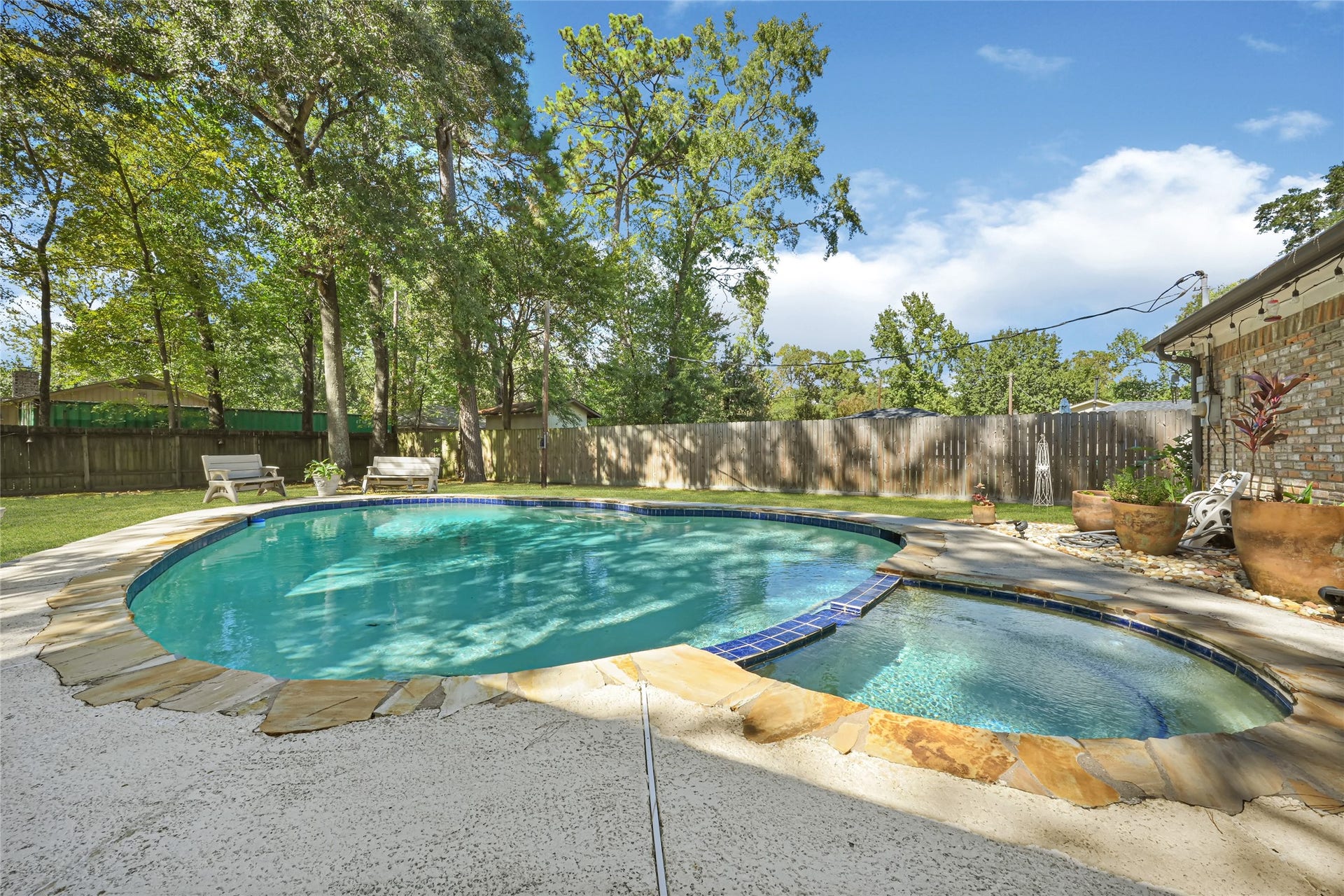 25803 Maplewood Drive, Spring, TX 77386 Relax in your own private oasis featuring a sparkling pool surrounded by lush trees and a spacious patio, perfect for outdoor entertaining.