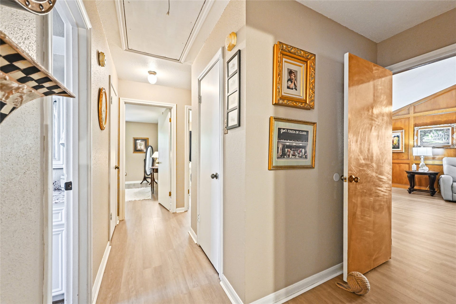 25803 Maplewood Drive, Spring, TX 77386 Bright hallway with light wood flooring, leading to multiple rooms. Adorned with framed artwork, it offers a warm and inviting transition to spacious living areas.