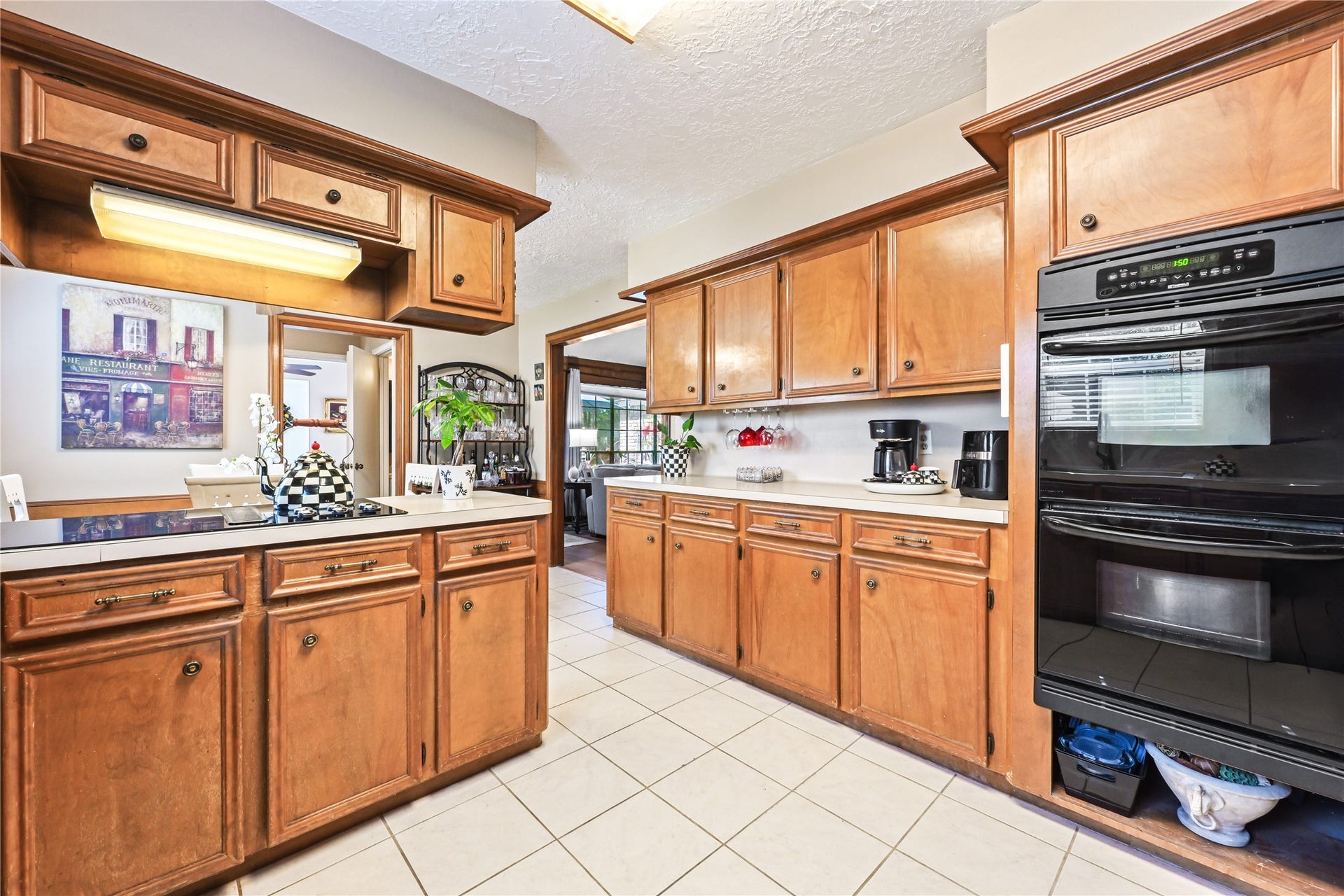 25803 Maplewood Drive, Spring, TX 77386 Spacious kitchen with warm wood cabinetry, sleek black appliances, and ample counter space, perfect for culinary enthusiasts.