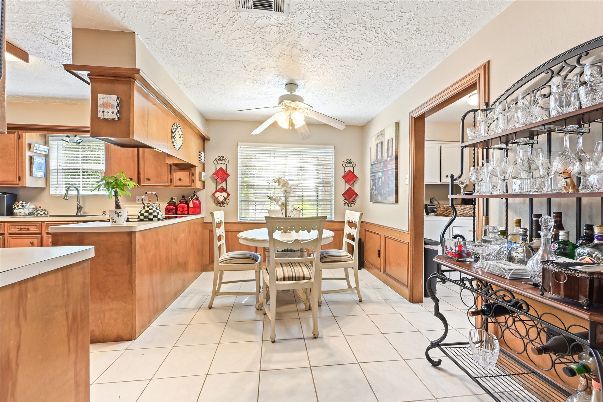 25803 Maplewood Drive, Spring, TX 77386 Charming kitchen and dining area featuring warm wood cabinetry, a cozy round table, and ample natural light. A decorative wine rack adds a touch of elegance, perfect for entertaining.