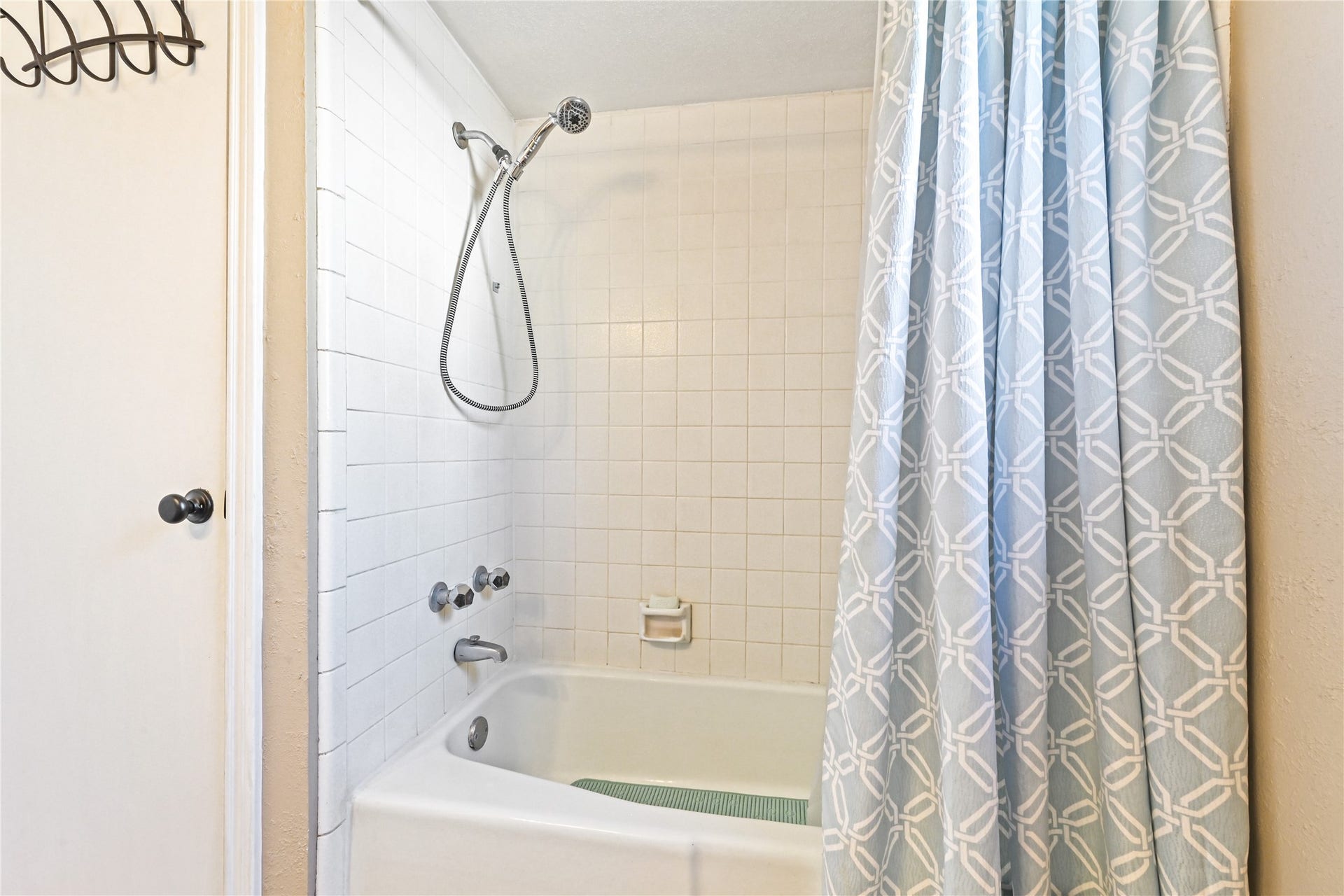 25803 Maplewood Drive, Spring, TX 77386 Cozy bathroom features a classic white tiled shower and tub combo, complemented by a stylish patterned shower curtain.