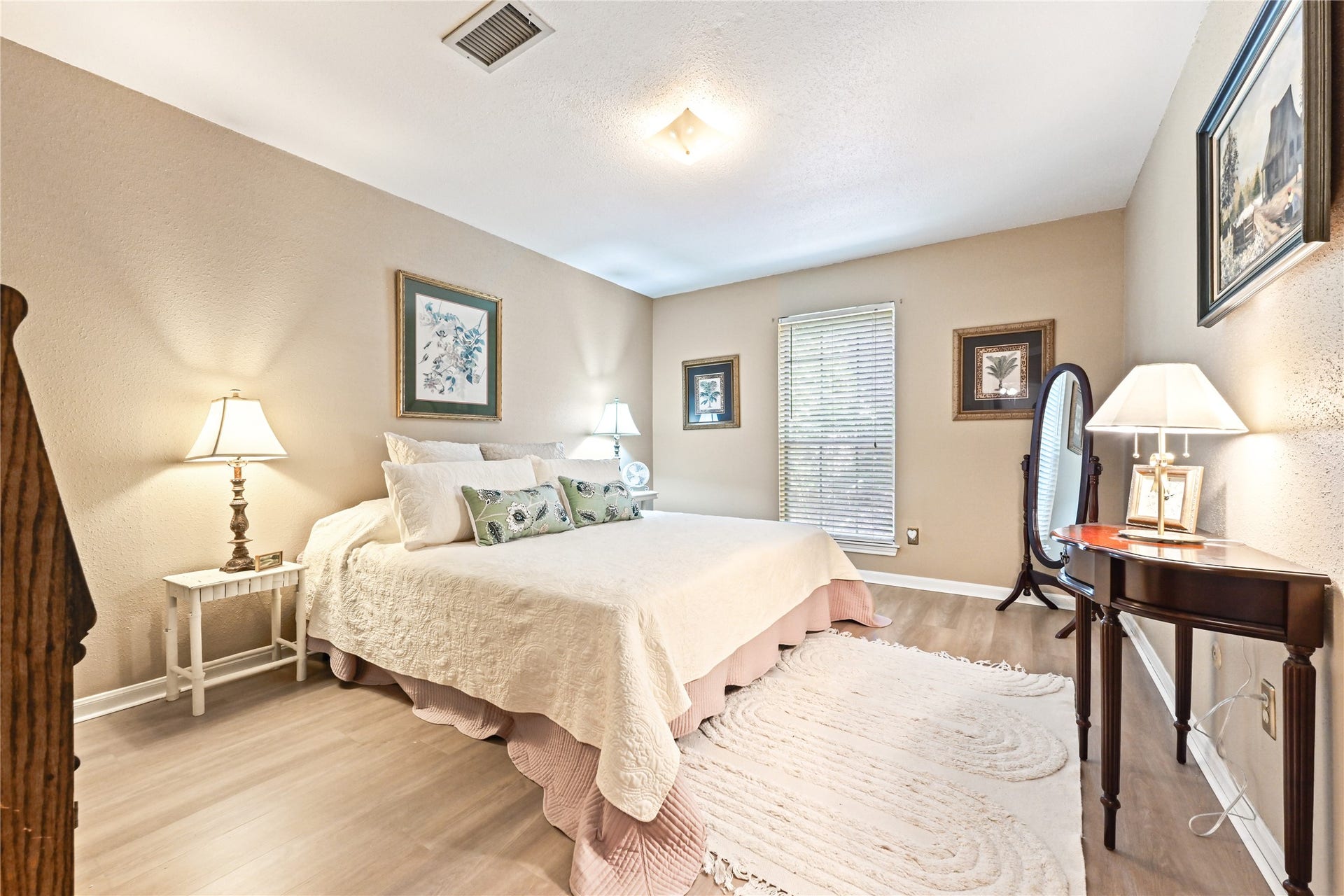 25803 Maplewood Drive, Spring, TX 77386 Cozy bedroom featuring soft neutral tones, elegant furnishings, and ample natural light from a large window, creating a serene and inviting atmosphere.