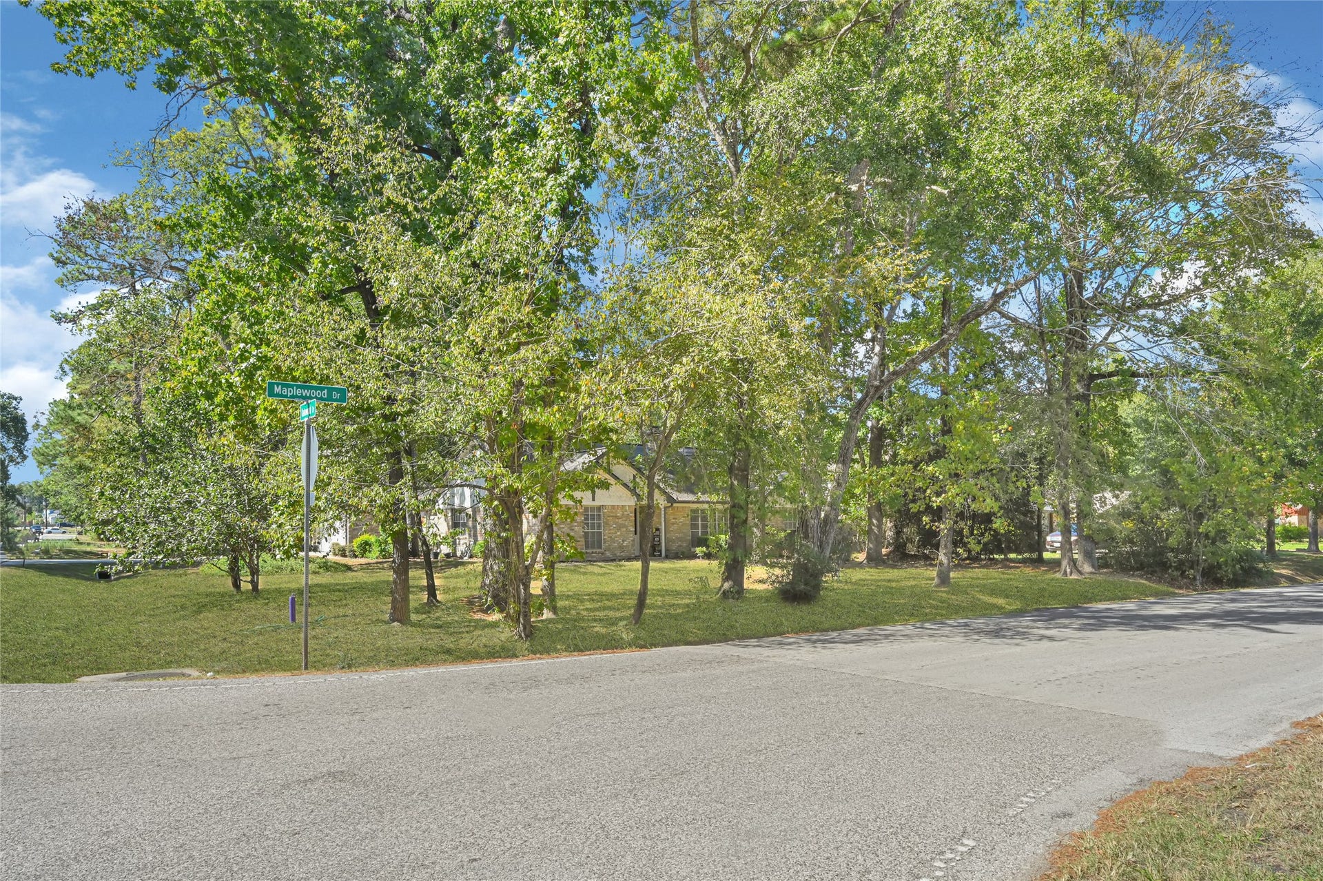 25803 Maplewood Drive, Spring, TX 77386 Charming home nestled on a spacious corner lot, surrounded by mature trees offering ample shade and privacy.