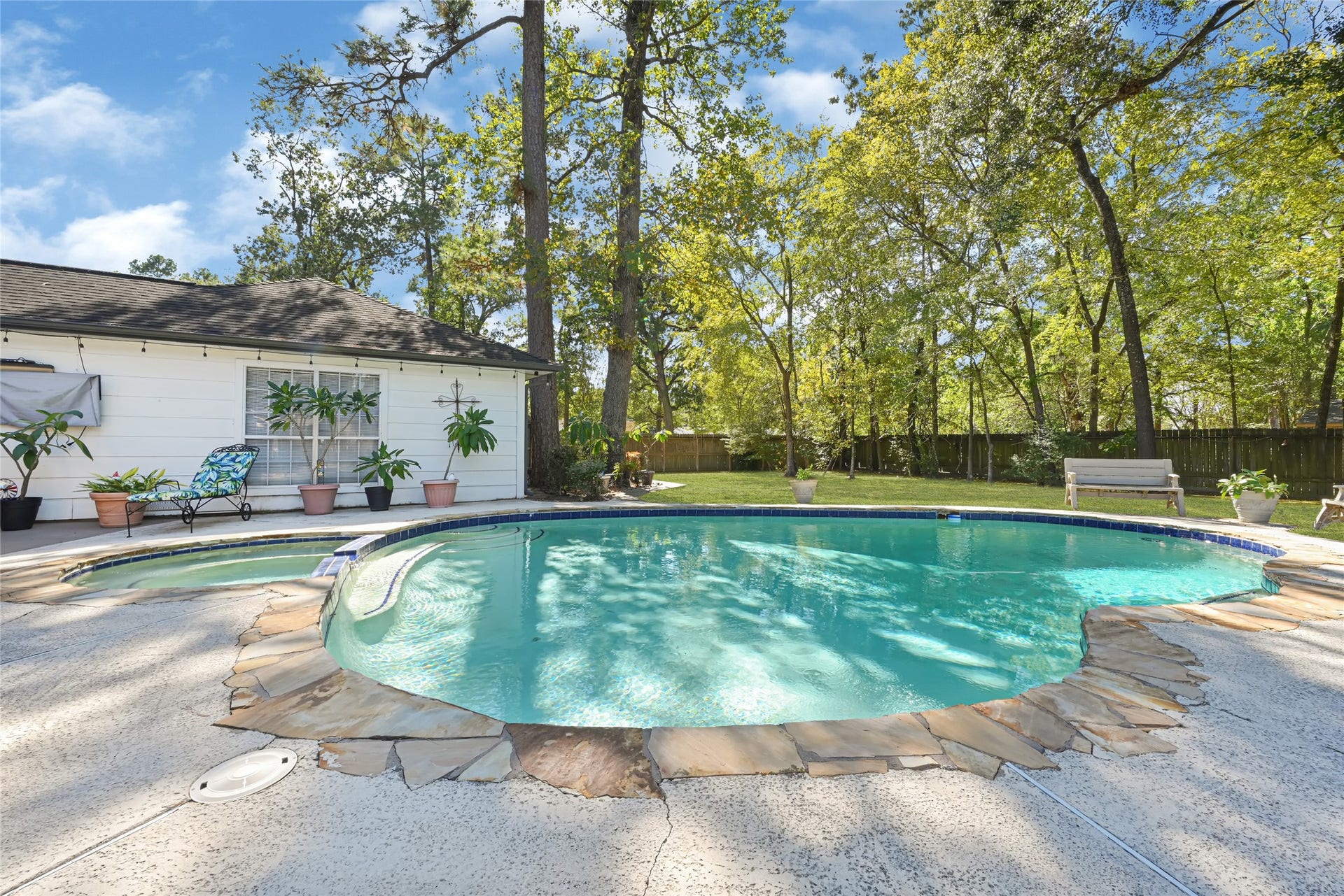 25803 Maplewood Drive, Spring, TX 77386 Enjoy a serene backyard oasis featuring a sparkling pool surrounded by lush greenery and ample patio space, perfect for relaxation and entertaining.