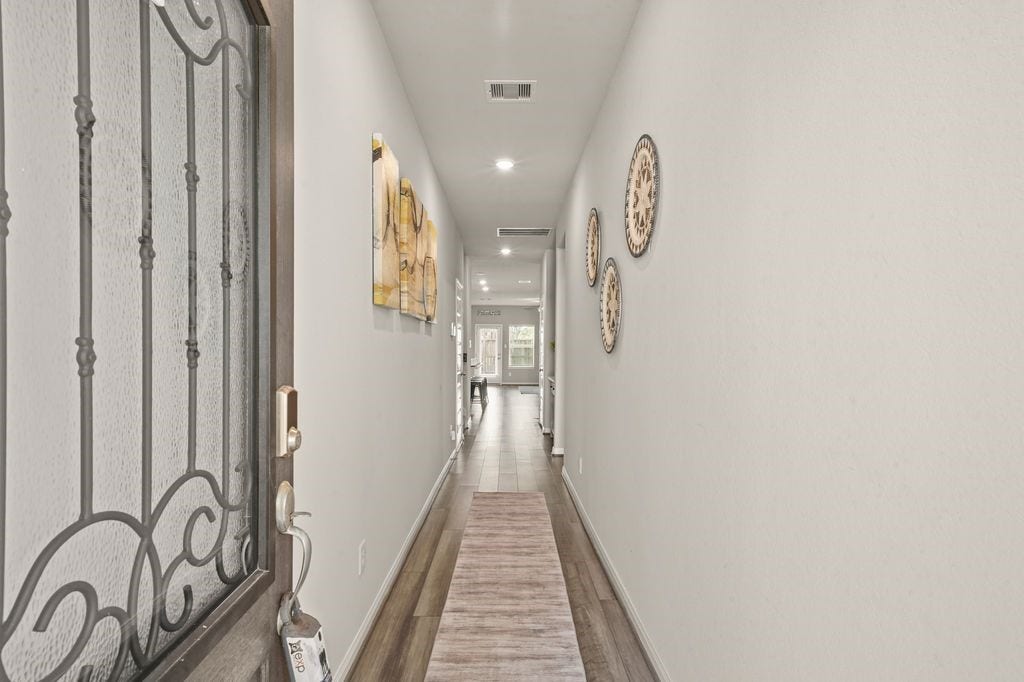 Entry Hallway: Bright entry with modern dcor and sleek wood floors leading to the open living area.