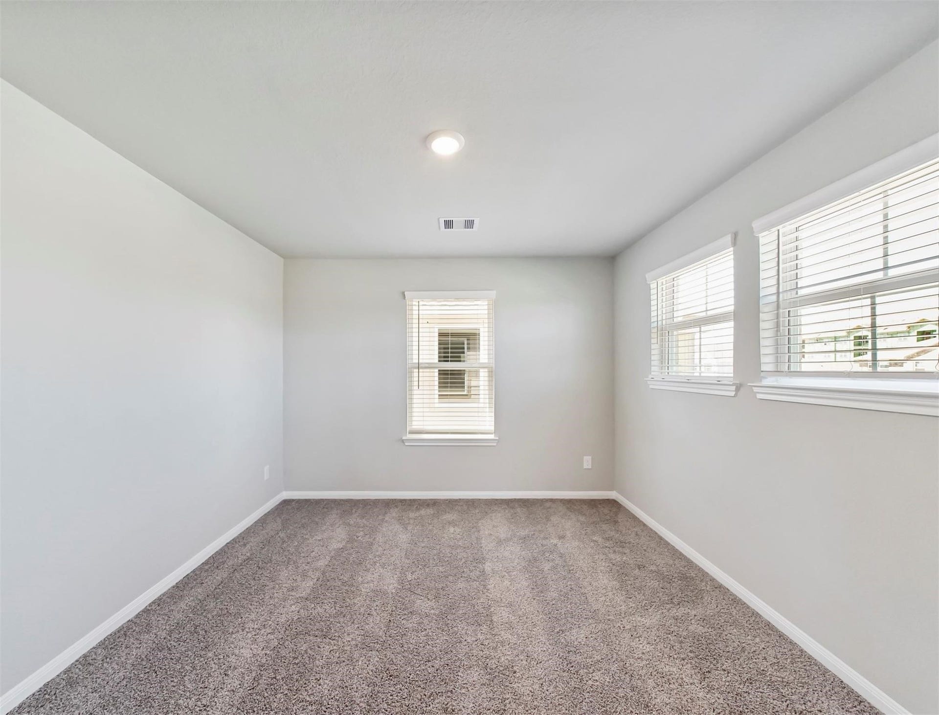 Private flex room with bright windows and neutral finishesideal for a home office, study, or creative retreat.