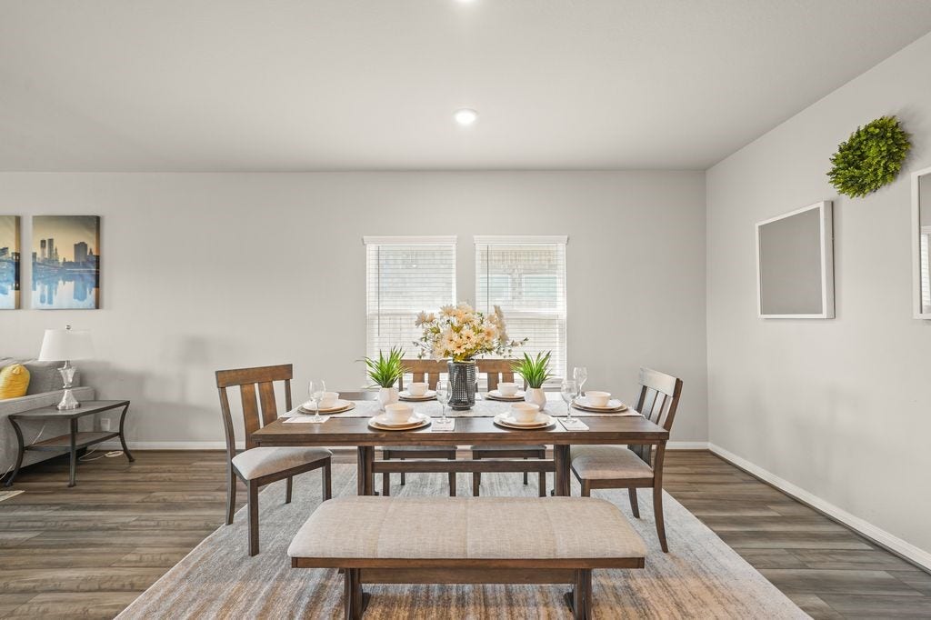 Spacious open-concept dining and living space with fabulous flooring, abundant natural light, and a neutral palette perfect for any decor style.