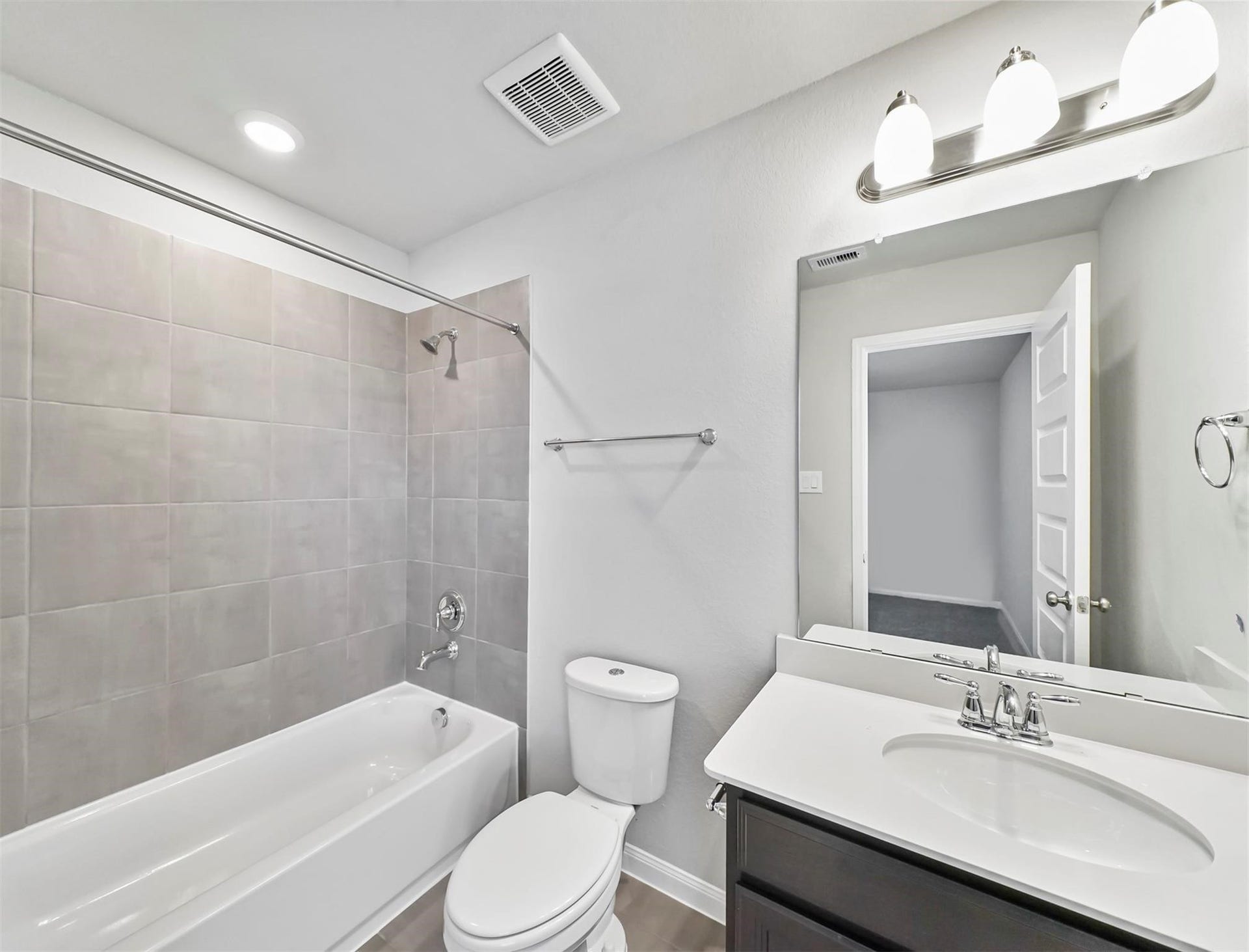 Full Bath accompanied with tub/shower with tile surround, dual sinks, and charming cabinetry.