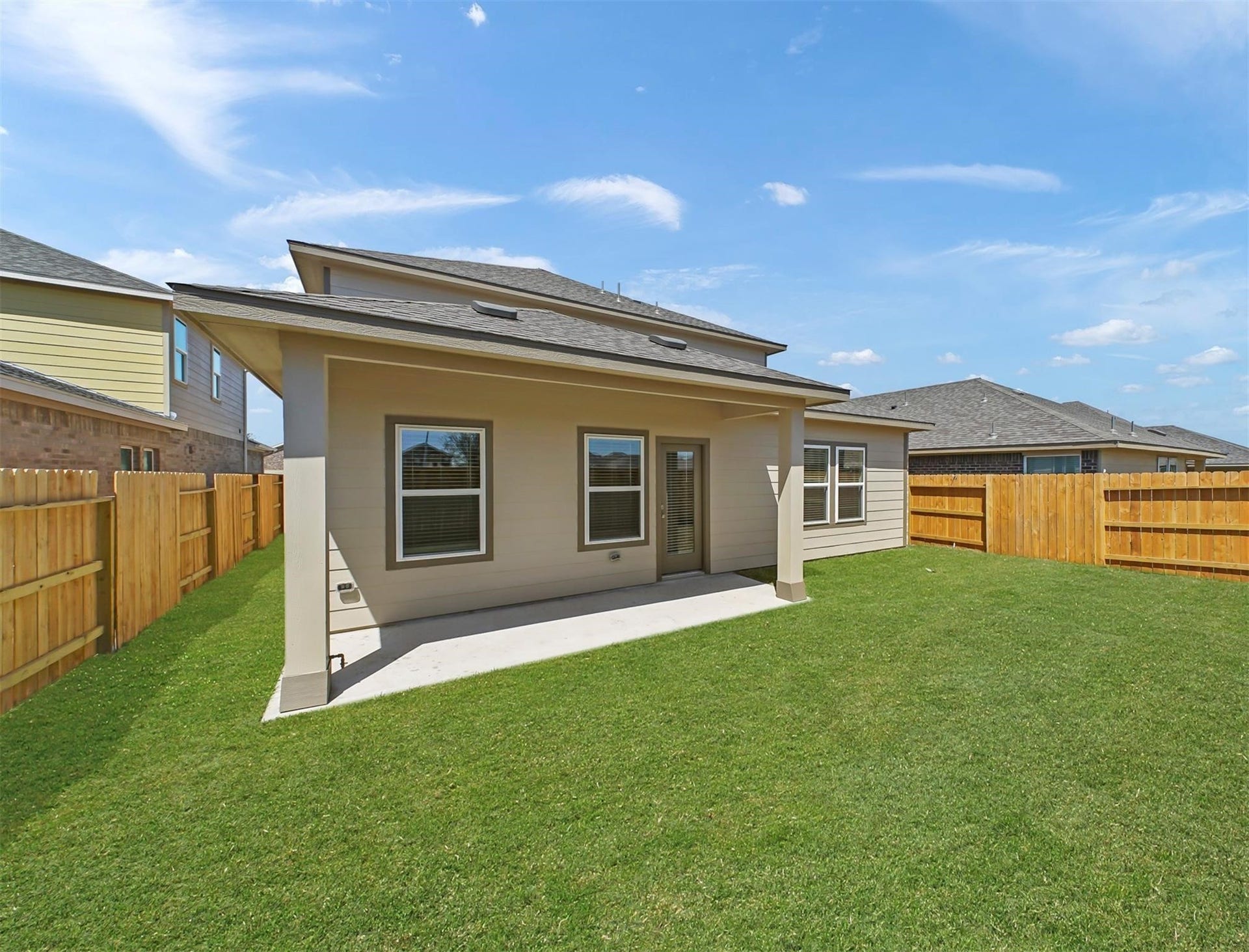 Alternate view of the extended covered patio and lush backyardideal for entertaining, play, or creating your dream outdoor retreat.