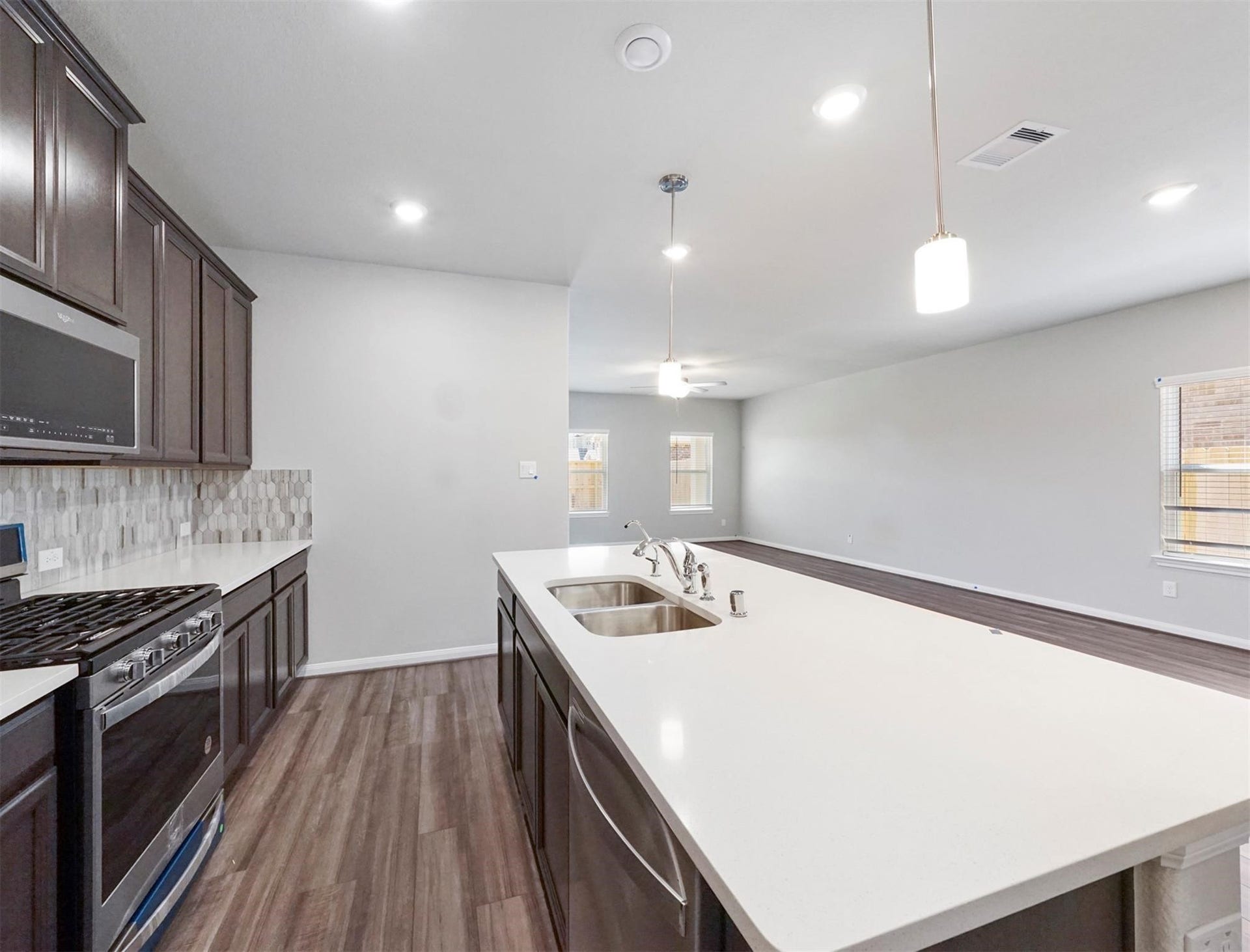 The oversized island with breakfast bar seating is the heart of this chefs kitchen, offering ample prep space and a view into the open living area.