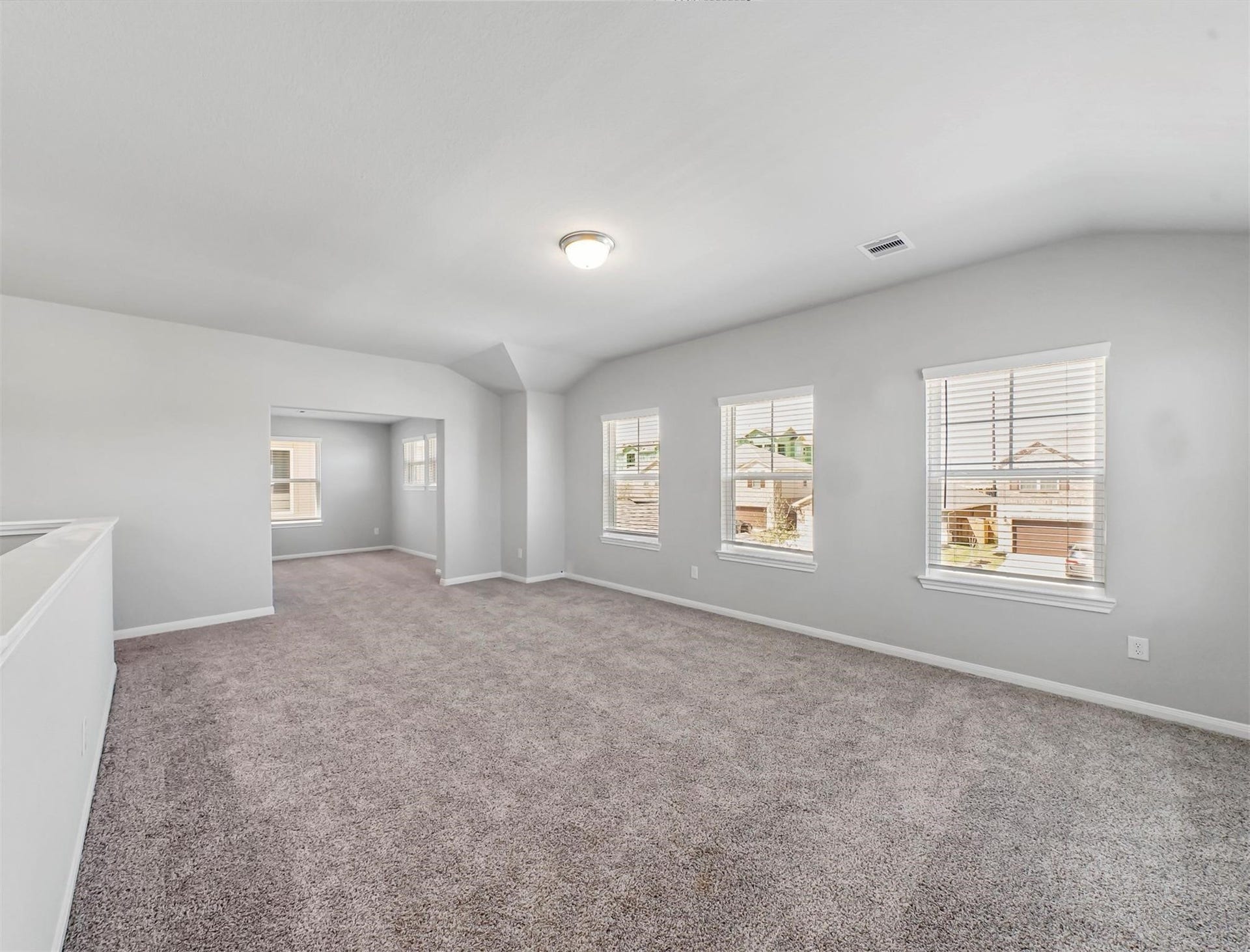 Spacious upstairs gameroom filled with natural light from multiple windowsperfect for a playroom, media lounge, or game area.