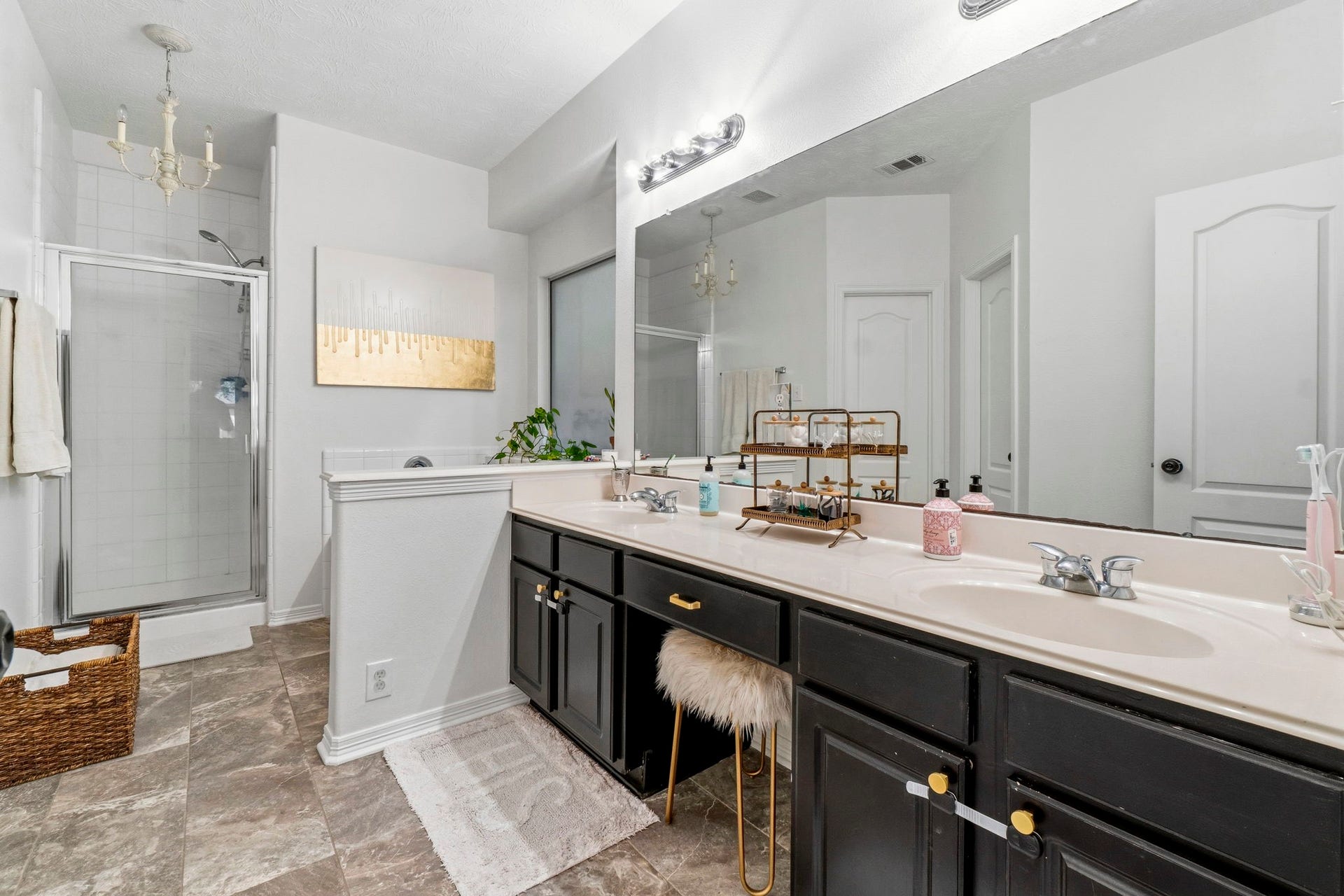 34019 Conroe Huffsmith Road, Magnolia, TX 77354 Spacious bathroom featuring a double vanity with elegant black cabinetry, a large mirror, and a walk-in shower.