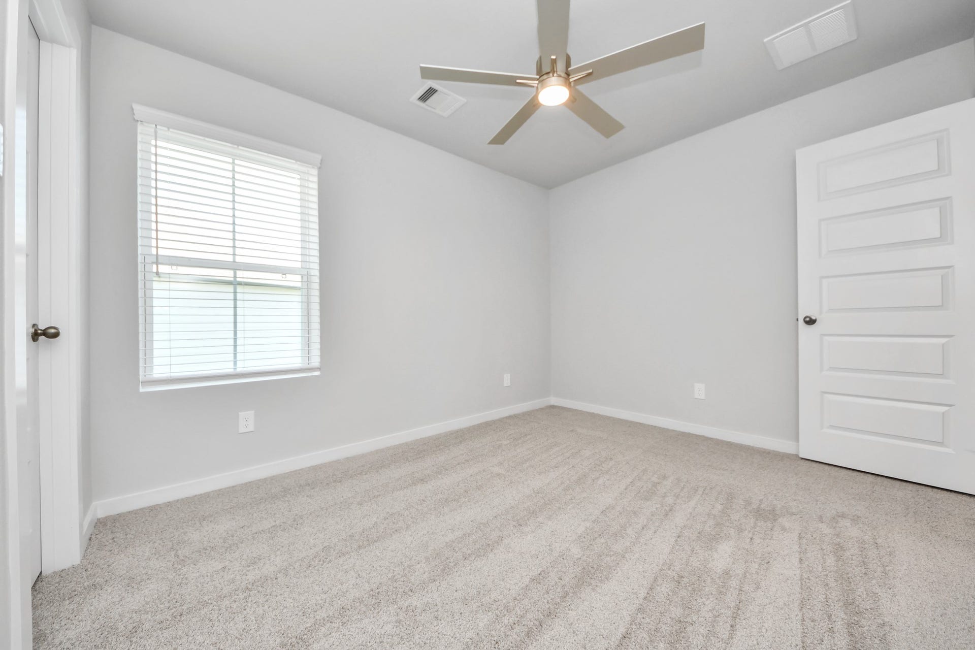 Secondary bedroom features plush carpeting, large windows that let in plenty of natural light, bright paint, and spacious closets. Sample photo of completed home with similar floor plan. Actual colors and selections may vary.