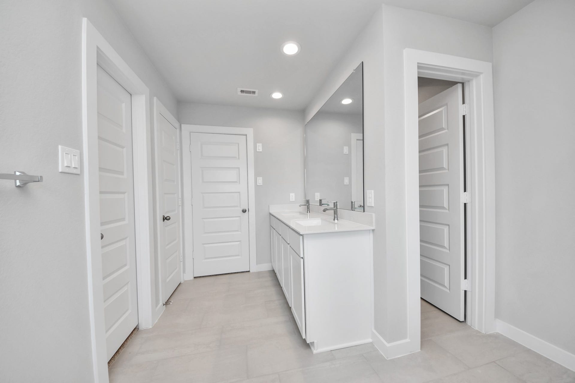 Elevate your daily routine at the elegant vanity, now equipped with double sinks, light countertops, modern hardware, and beautiful recessed lights. Sample photo of completed home with similar floor plan. Actual colors and selections may vary.