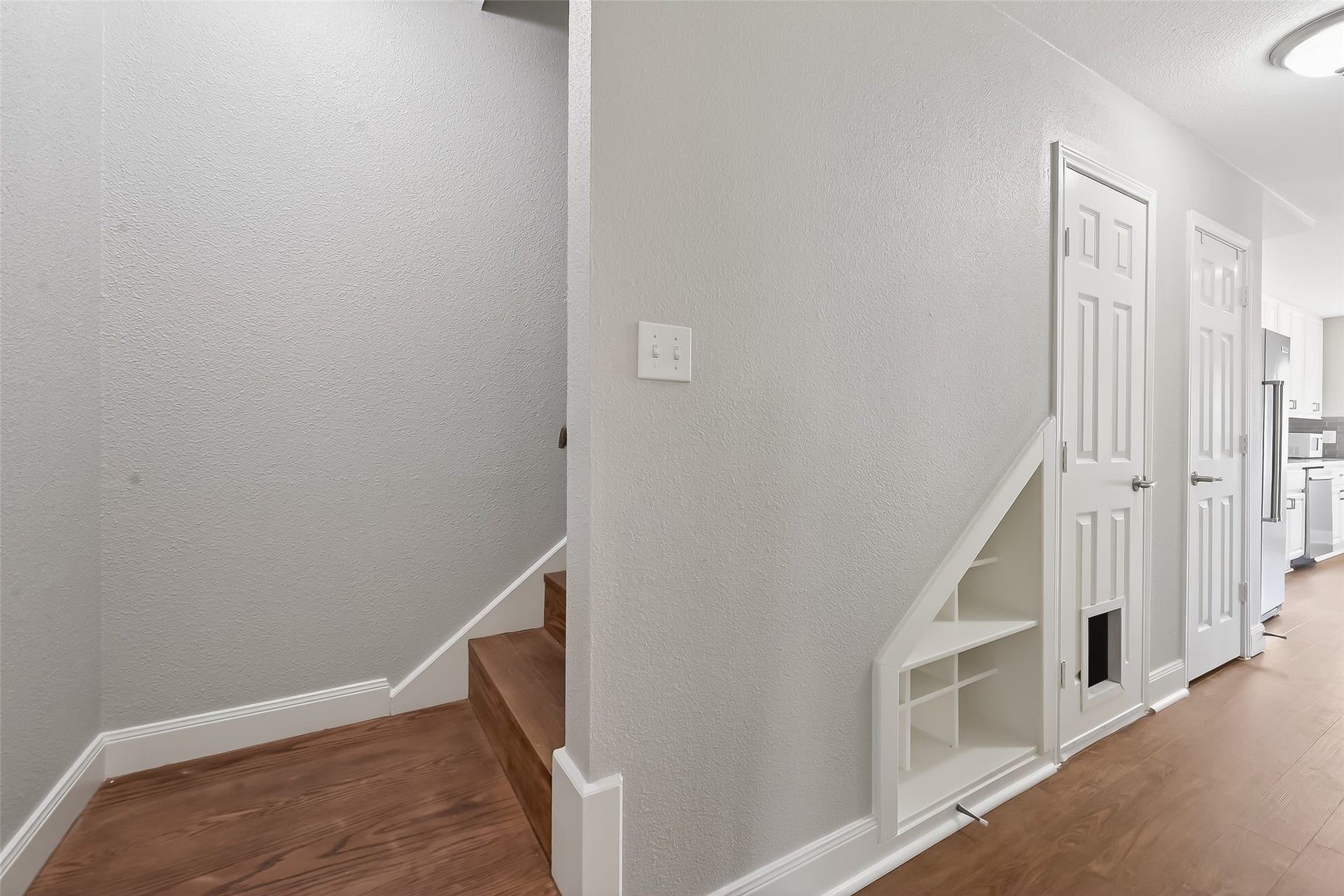 6351 Briar Rose Drive, #149, Houston, TX 77057 Updated stairwell with wood tread stairs, built-in shelving, and additional storage closet offering functional organization and smart use of space in this Houston townhom
