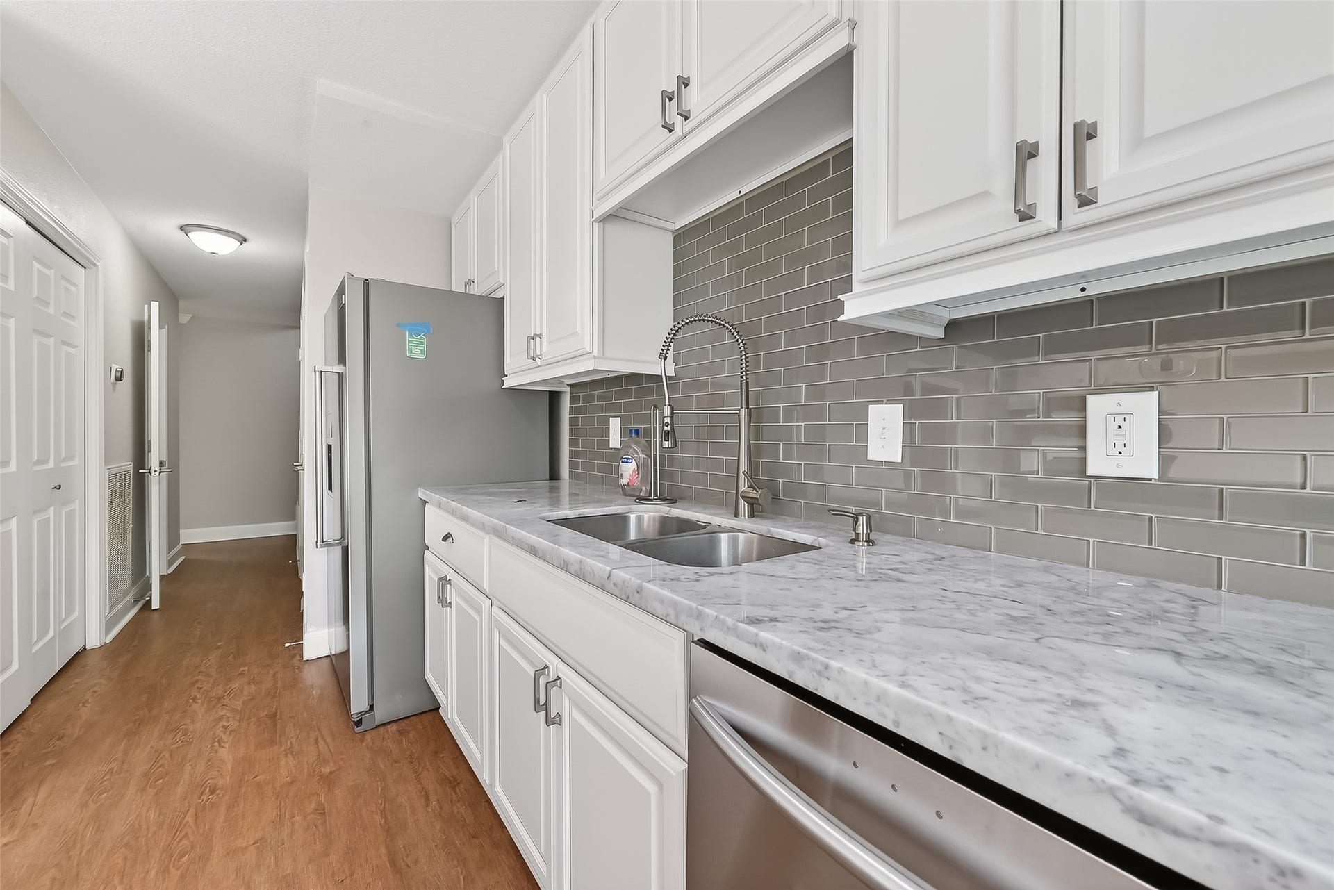 6351 Briar Rose Drive, #149, Houston, TX 77057 Beautifully renovated kitchen featuring KitchenAid refrigerator, marble countertops, and abundant cabinet storage.