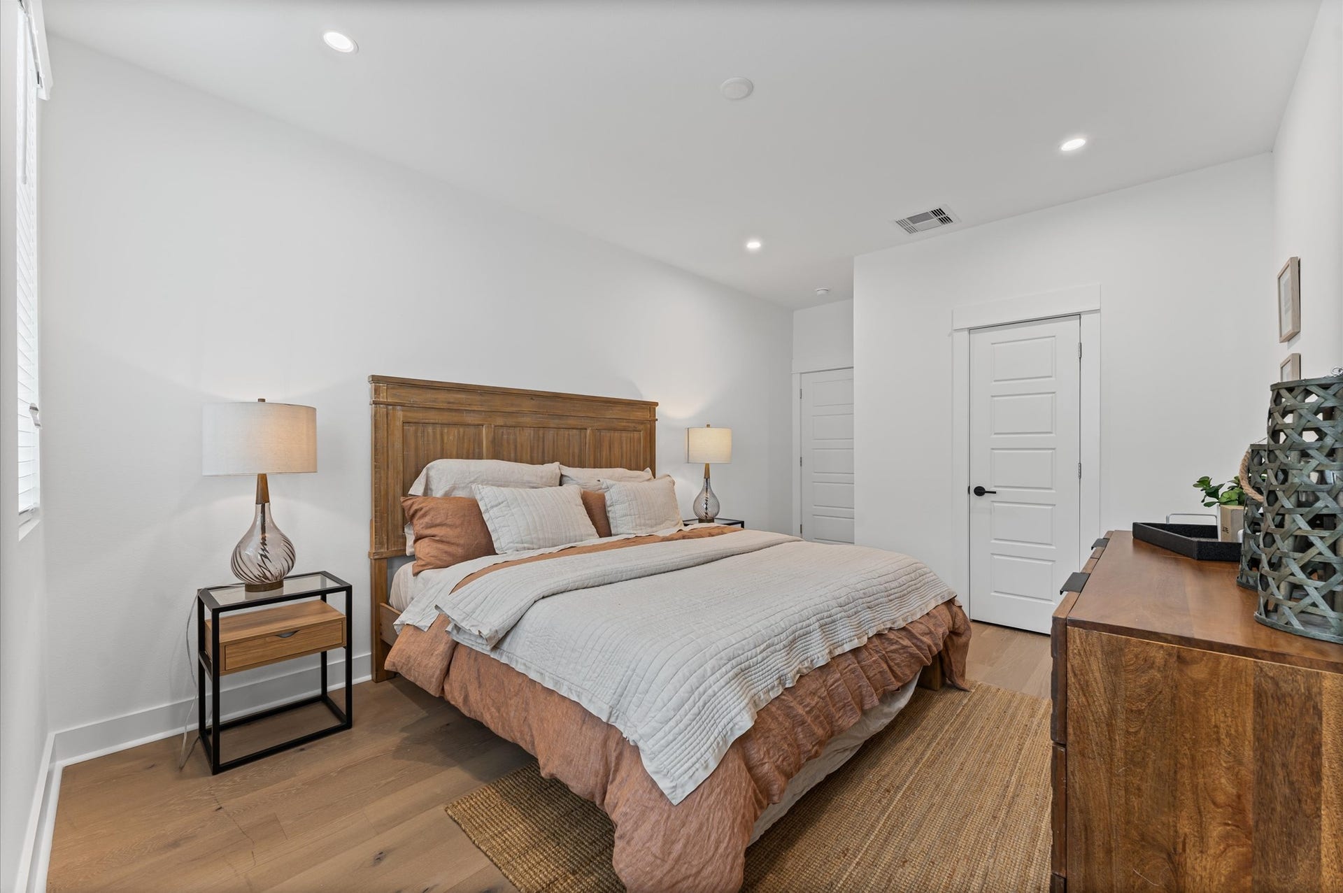 412 Neyland Street, #F, Houston, TX 77022 This spacious second-floor primary bedroom exudes modern elegance with its sleek engineered wood flooring that adds warmth and texture underfoot. Soaring high ceilings amplify the sense of openness, allowing natural light to cascade in and highlight the rooms architectural charm. Whether styled with minimalist furnishings or layered with cozy accents, the space offers a serene retreat elevated by its refined finishes and elevated vantage point.