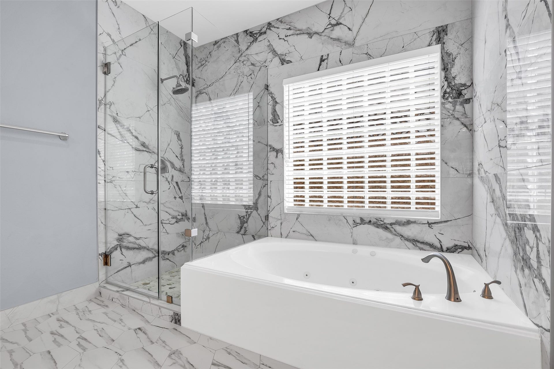 10626 Cortland Ridge Lane, Cypress, TX 77433 Indulge in luxury within this stunning primary bath, featuring elegant marble walls, a sleek glass-enclosed shower, and a sumptuous soaking tub for ultimate relaxation.