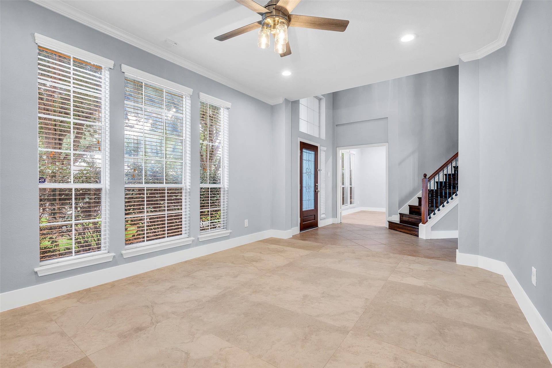 10626 Cortland Ridge Lane, Cypress, TX 77433 Bright and welcoming dining room with large windows, modern tile flooring, and a stylish ceiling fan