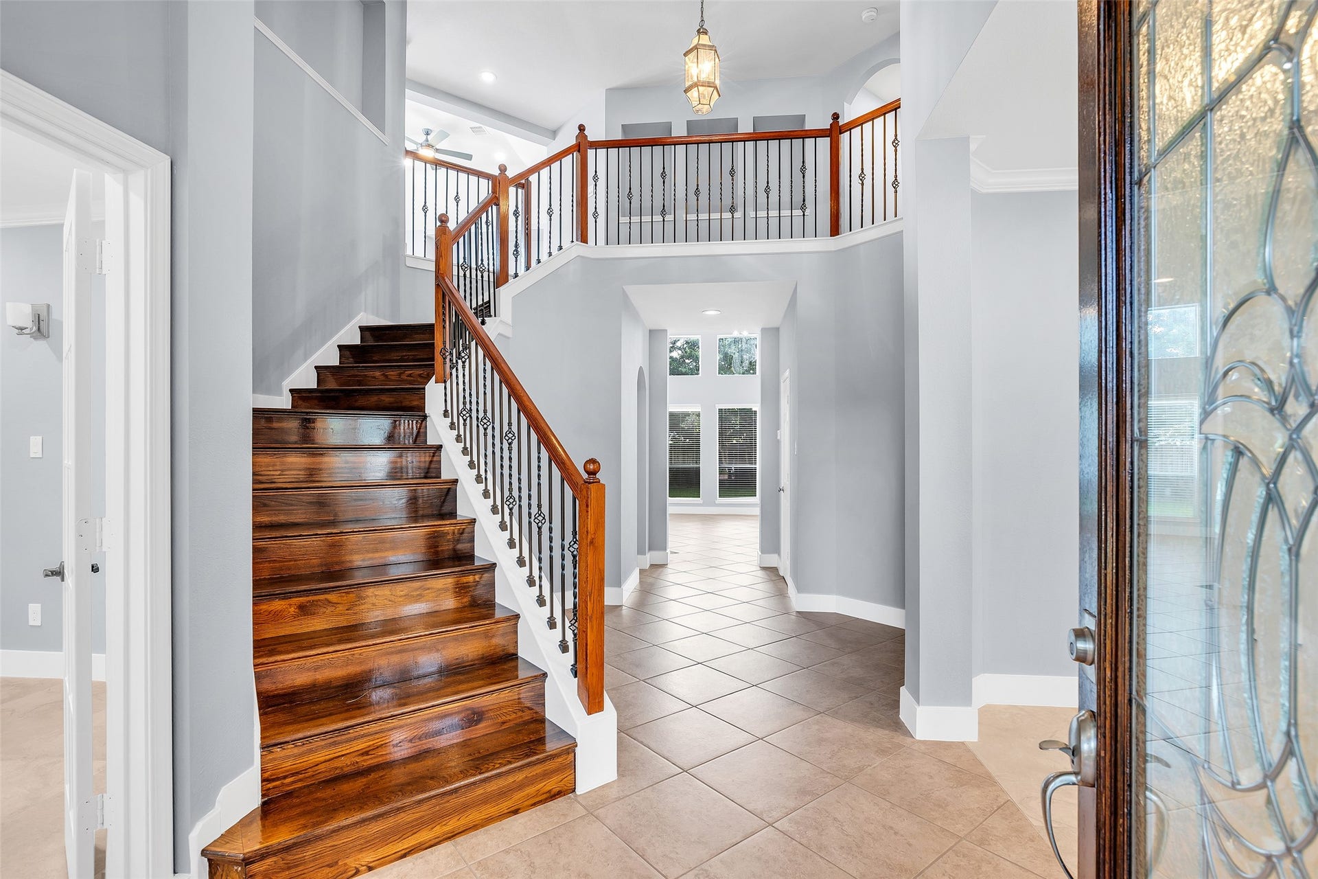 10626 Cortland Ridge Lane, Cypress, TX 77433 Grand entryway featuring a striking wooden staircase complemented by high ceilings and abundant natural light from large windows.