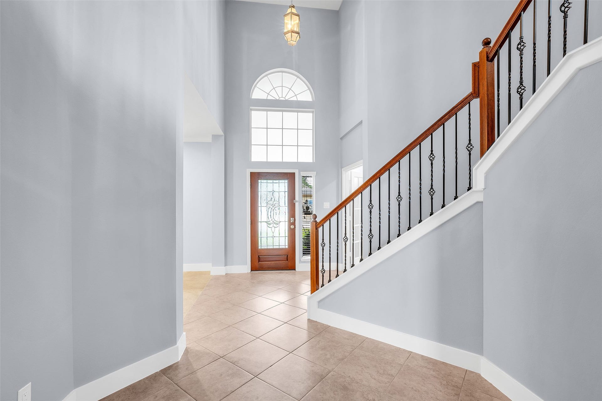 10626 Cortland Ridge Lane, Cypress, TX 77433 Elegant entryway featuring a grand staircase with high ceilings, and a decorative glass front door that welcomes natural light.