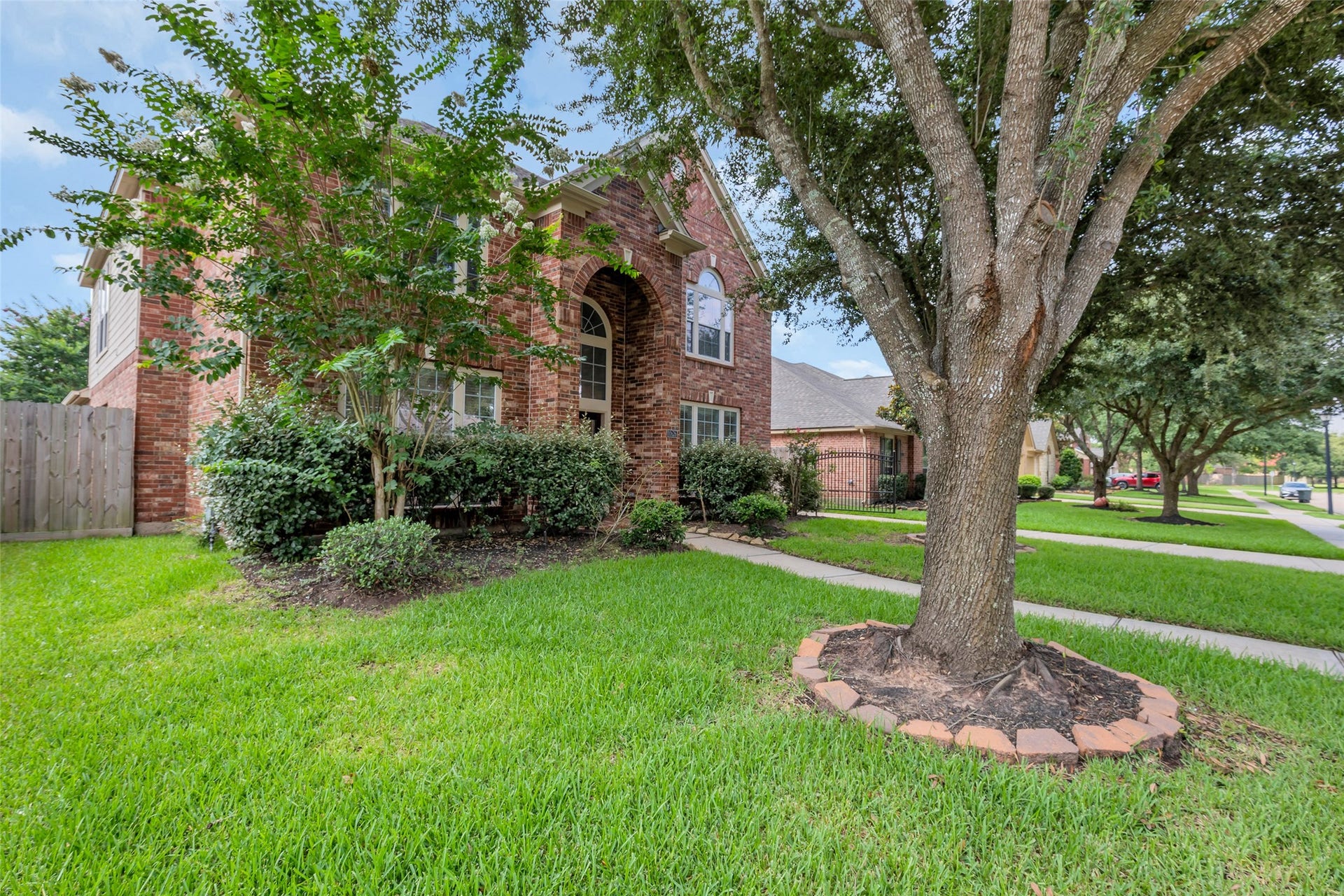 10626 Cortland Ridge Lane, Cypress, TX 77433 Charming brick home with lush landscaping and mature trees, offering inviting curb appeal on a corner lot.