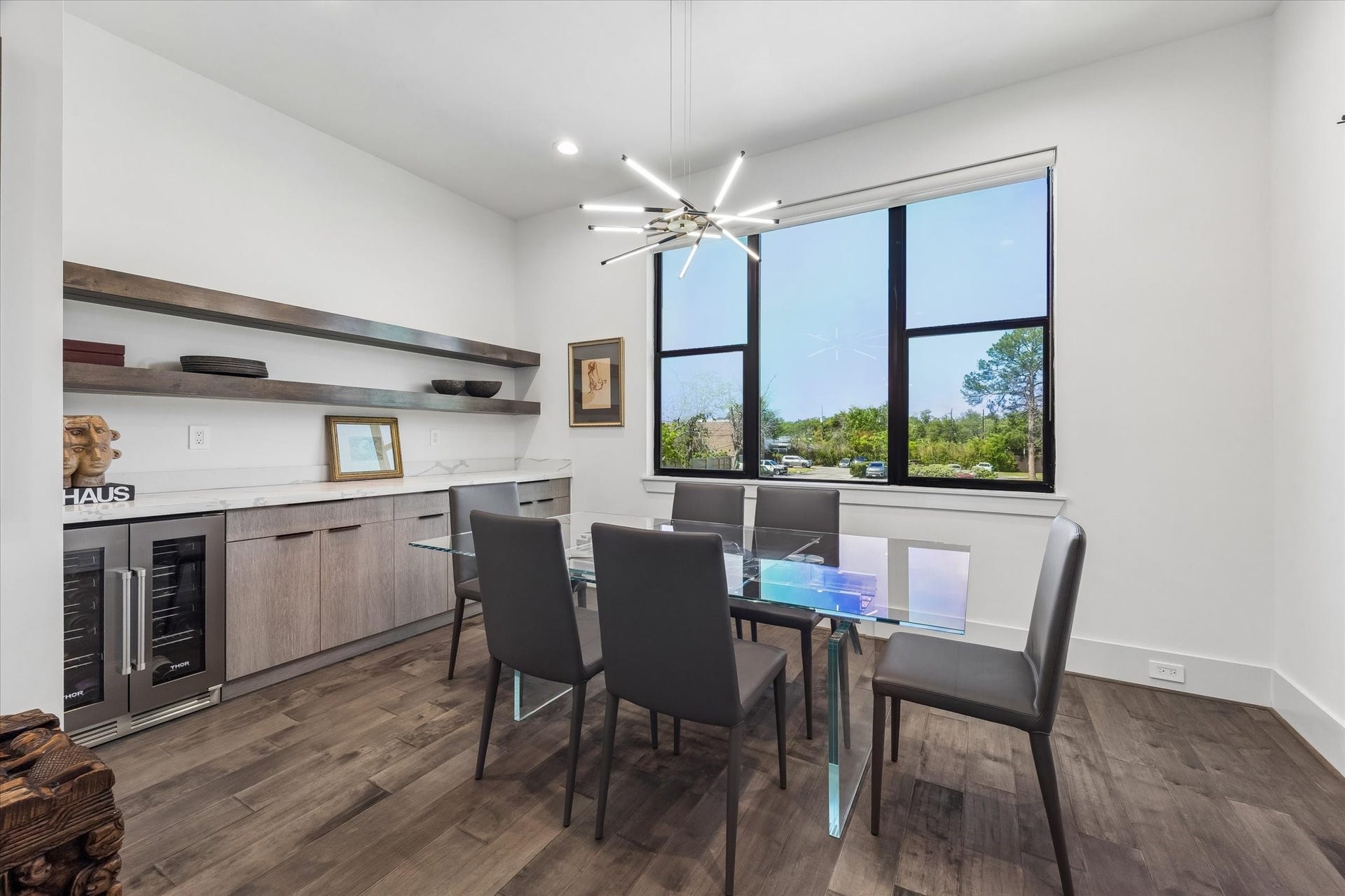 2435 Sheridan Street, Houston, TX 77030 The elegant dining room features a modern chandelier, large window with sunset views, sleek cabinetry, and a built-in wine cooler.