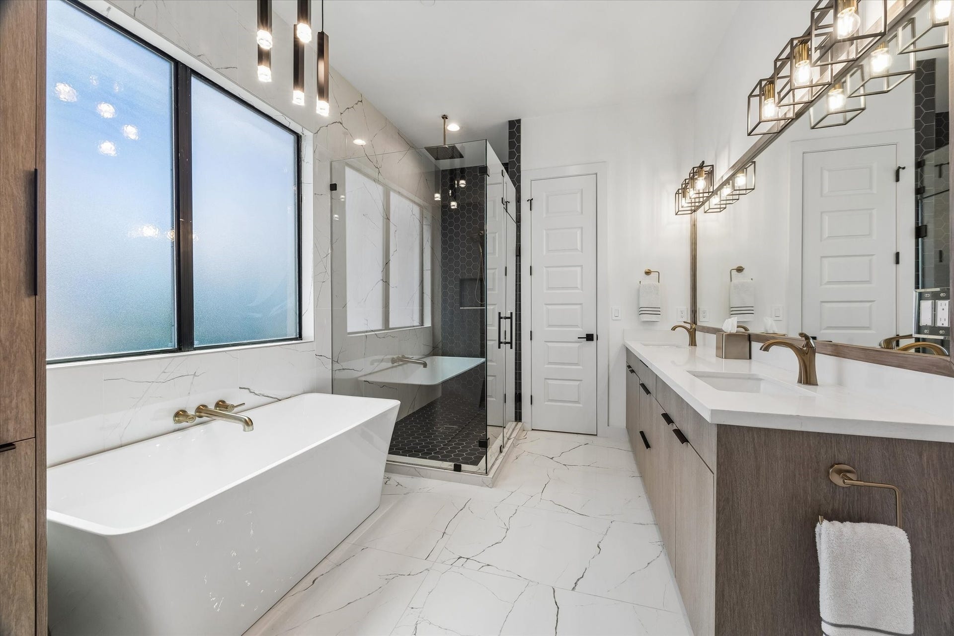 2435 Sheridan Street, Houston, TX 77030 Luxurious primary bathroom featuring a sleek glass shower, elegant soaking tub, dual sinks, and modern lighting for a spa-like retreat.