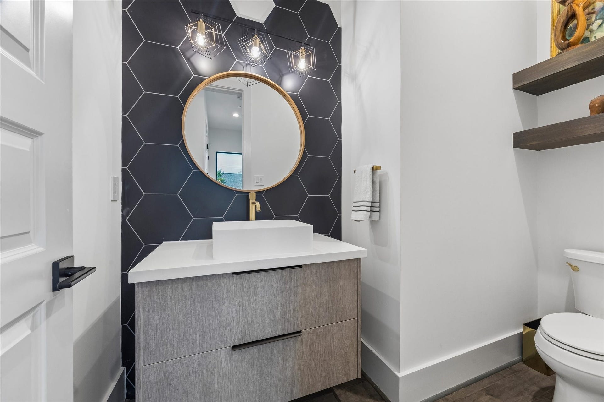 2435 Sheridan Street, Houston, TX 77030 Stylish half bath with modern fixtures and a sleek hexagonal tile accent wall.